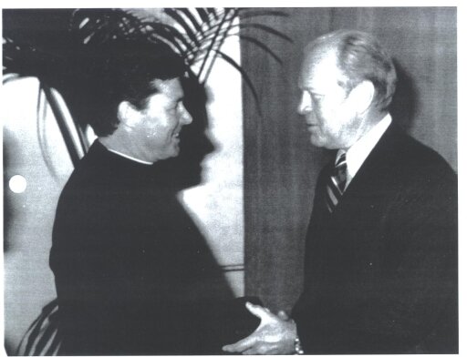 Father Riley shaking hands with former president Gerald Ford.