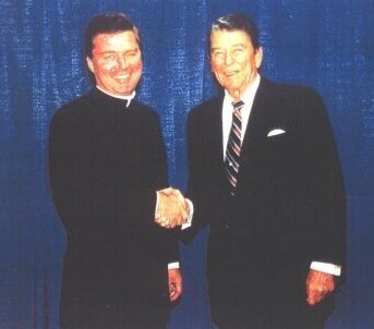 Father Riley shaking hands with former presidents Ronald Reagan.