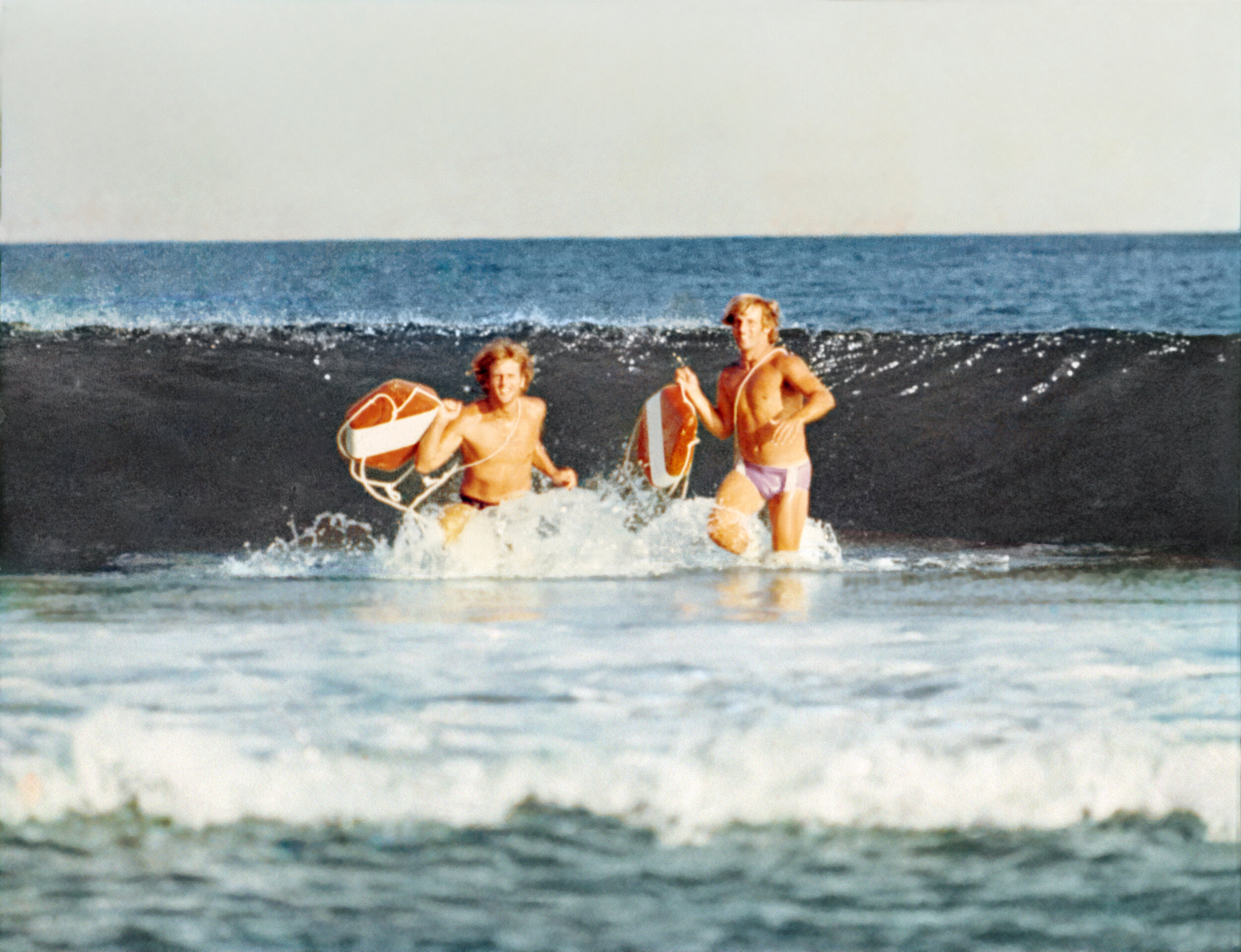 Rescue cans were a lot larger in 1972 when Mike Smith (right) was running out of the surf with Ricky Pons.