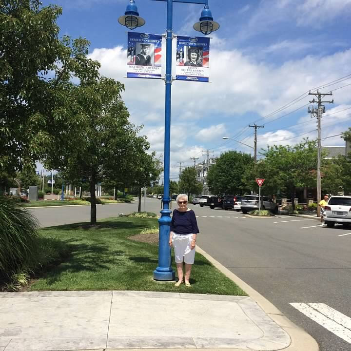 Ellen Byrnes poses with hometown hero  banners honoring herself and her husband Matt at 22nd Street in 2015.