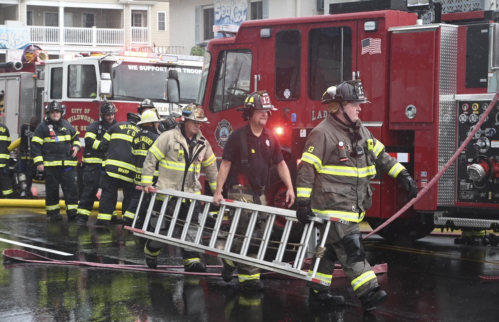 Chief Stanford, Orzech and Gay carry a ladder back to their truck after responding to the motel fire in Wildwood.