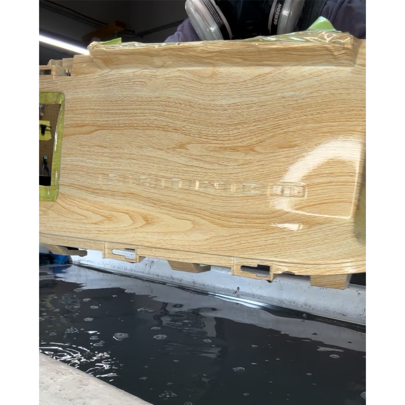 Close-up of a wooden object with a shiny finish, with the word cripture engraved or printed on it.