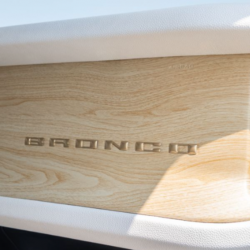 Close-up of a wooden surface with the brand name "BRONCO" in metallic letters.