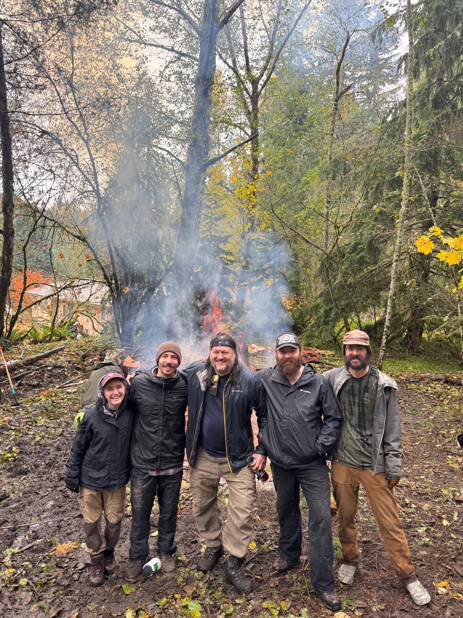 Participants gather in front of a burn pile
