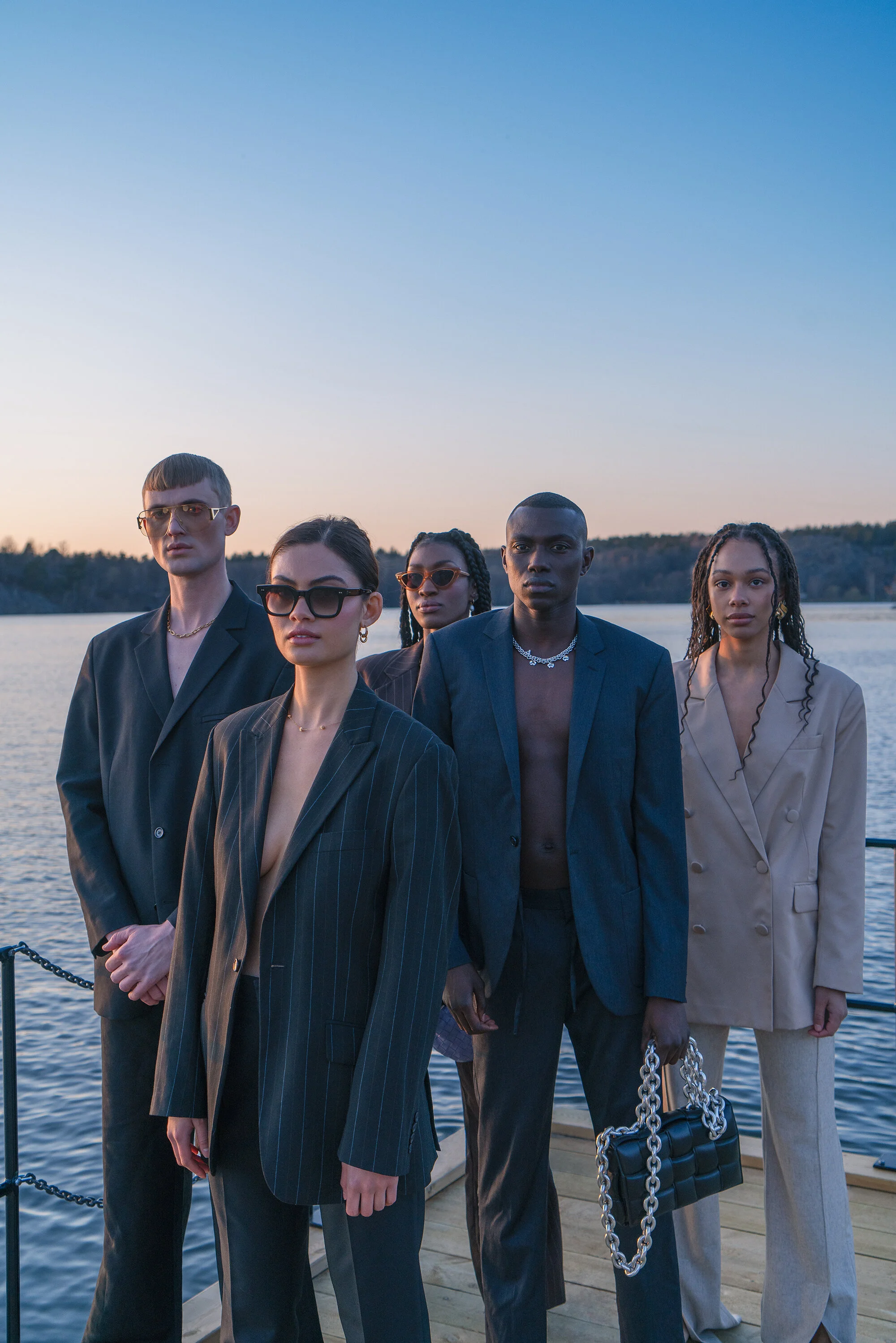 [L - R] Leo wears: Suit - HOPE Stockholm | Sunglasses - Bottega Veneta    Saga wears: Suit - Vintage | Sunglasses - CHIMI Eyewear | Earrings - Edblad    Mariama wears: Suit and Sunglasses - Vintage | Earrings - Edblad    Kande wears: Suit - Vintage | Necklace: Edblad | Bag - Bottega Veneta    Emmi wears: Blazer - Gina Tricot | Trousers - HOPE Stockholm | Earrings - Edblad