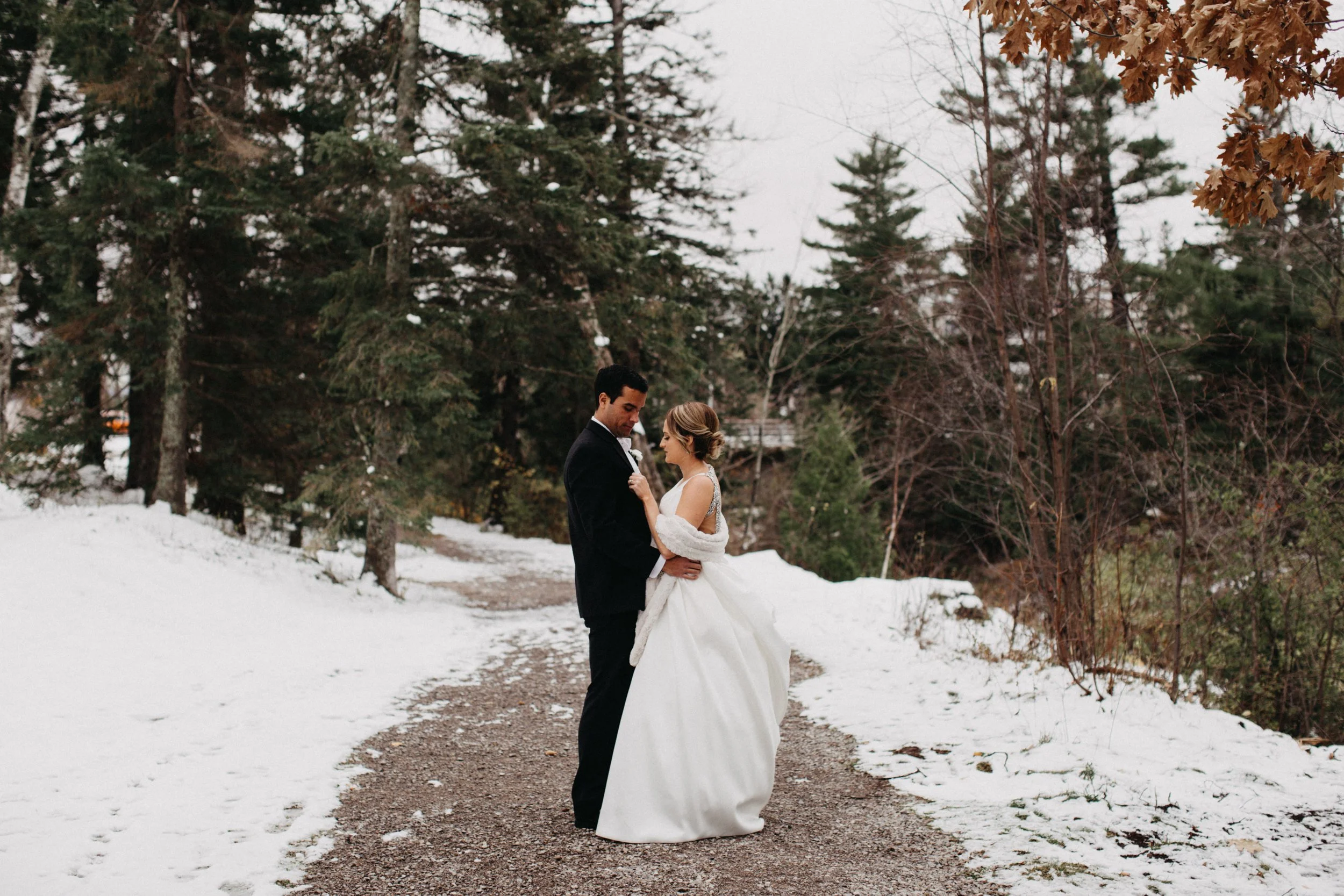 Couple standing in snowy Lester Park on their wedding day in Duluth, Minnesota