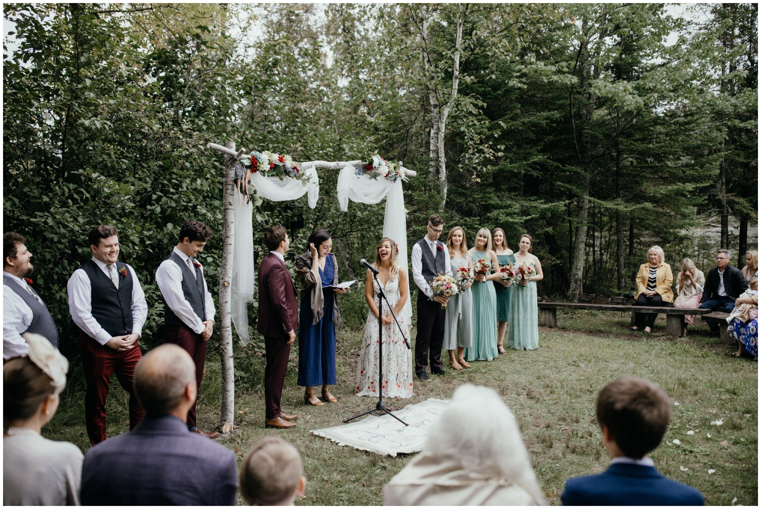 Groom reading his vows during Minnesota summer camp wedding in the woods