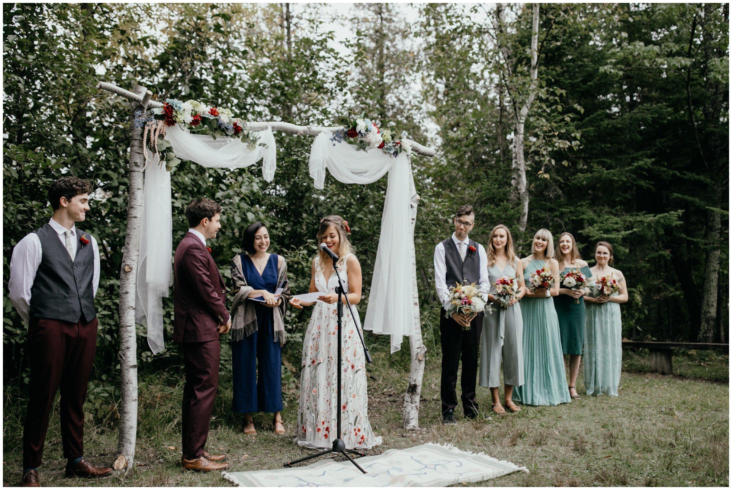Bride reading her vows during Minnesota summer camp wedding in the woods