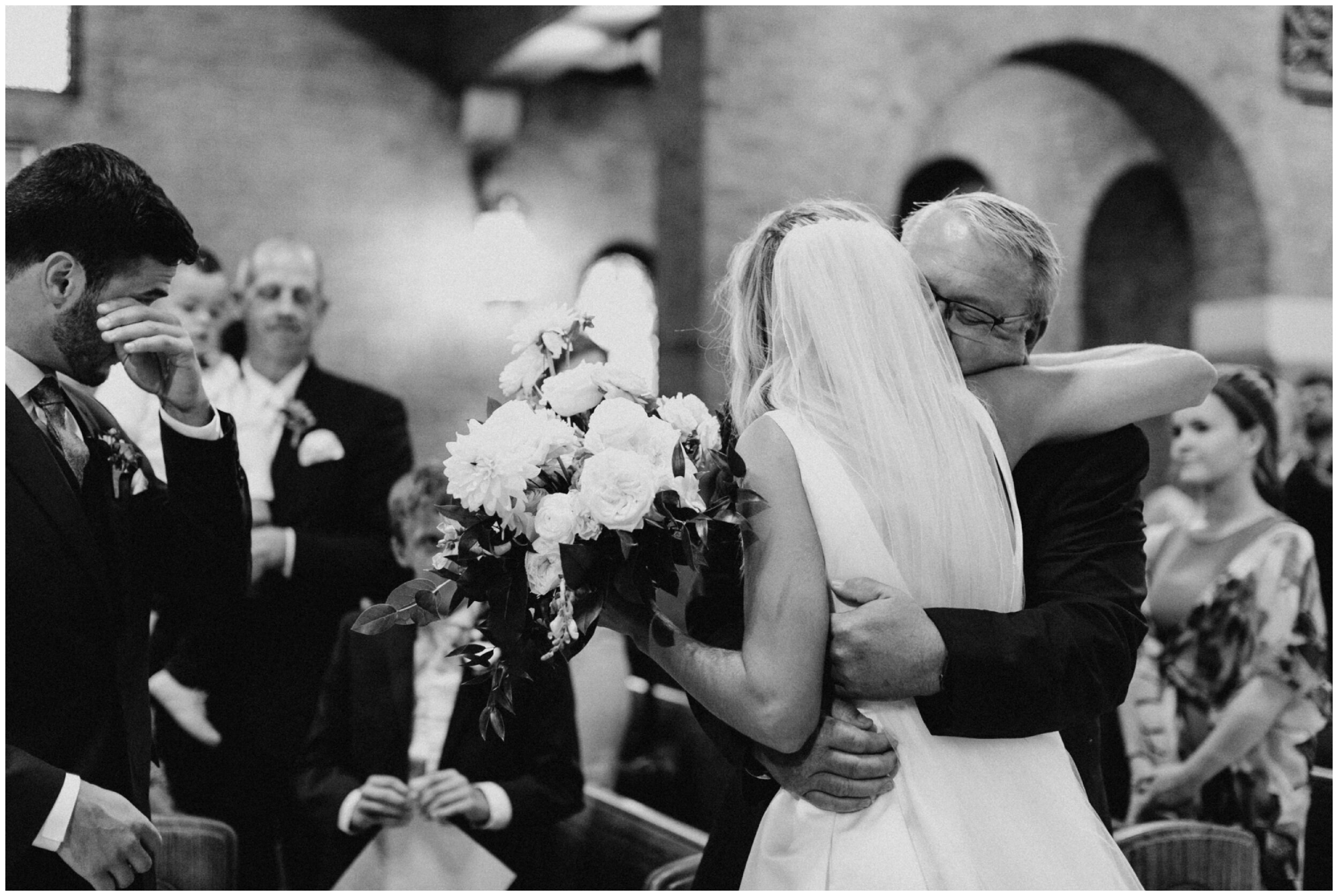 Emotional groom as bride hugs dad during Brainerd Minnesota wedding ceremony