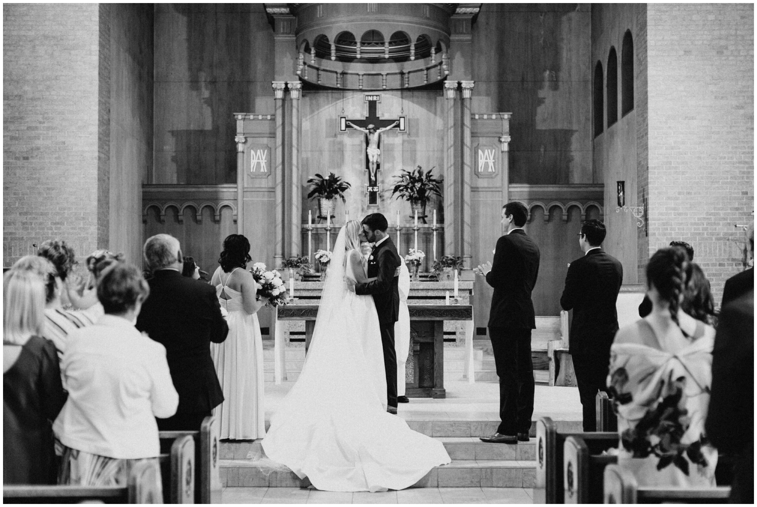 Bride and groom kiss during cathedral wedding ceremony in Brainerd Minnesota 