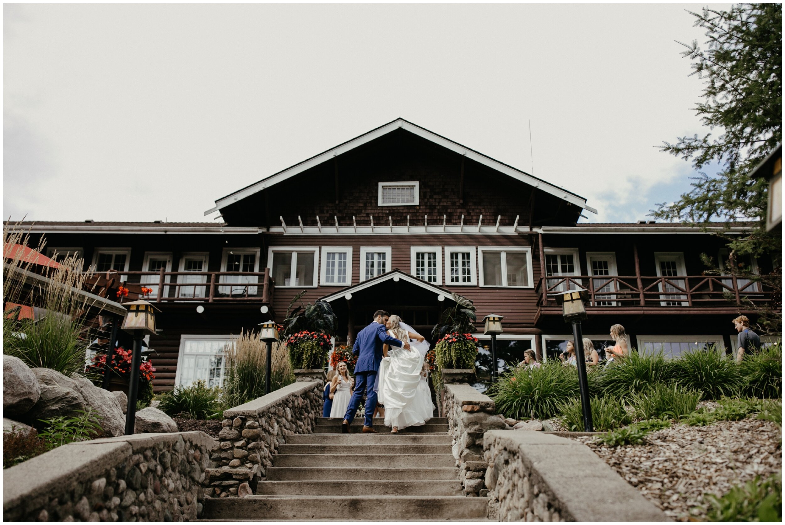 Bride and groom kissing while walking up staircase at Grand View Lodge in Nisswa, Minnesota