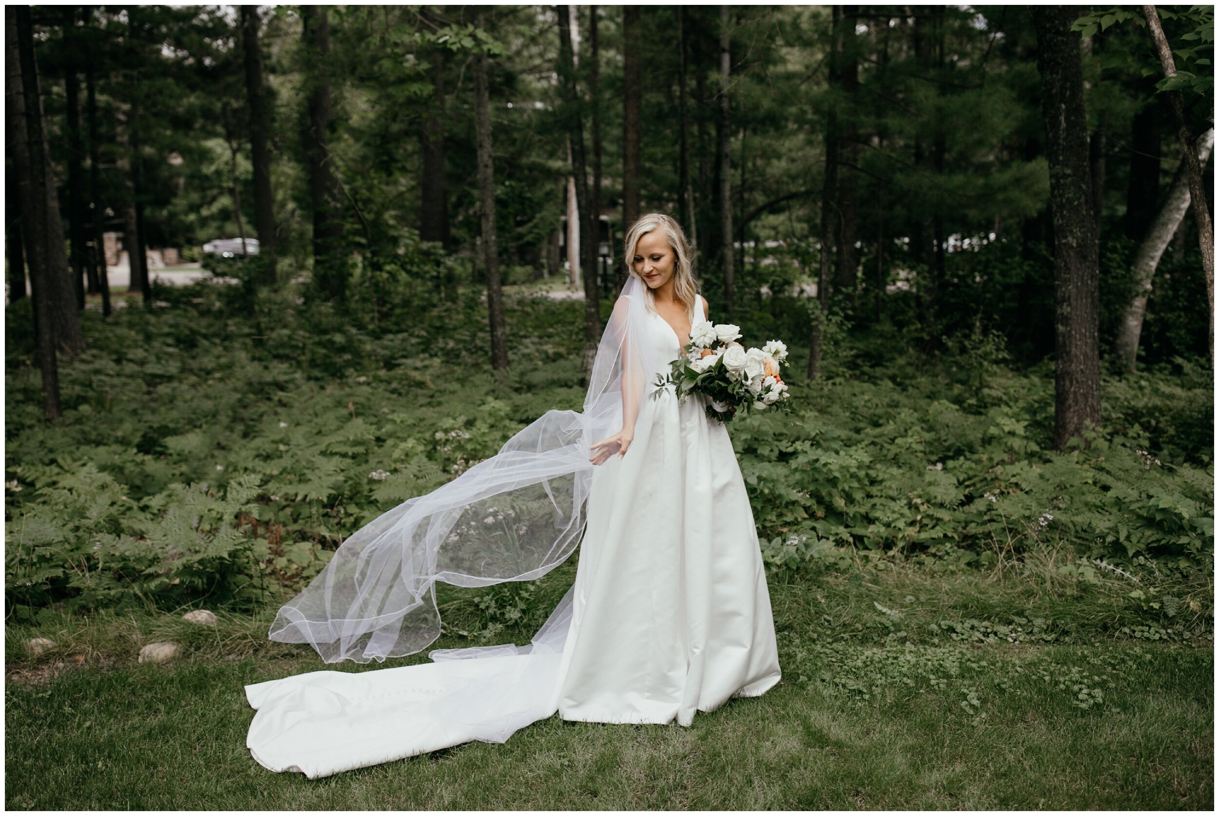 Bride playing with floor length veil during Grand View Lodge luxury Minnesota wedding