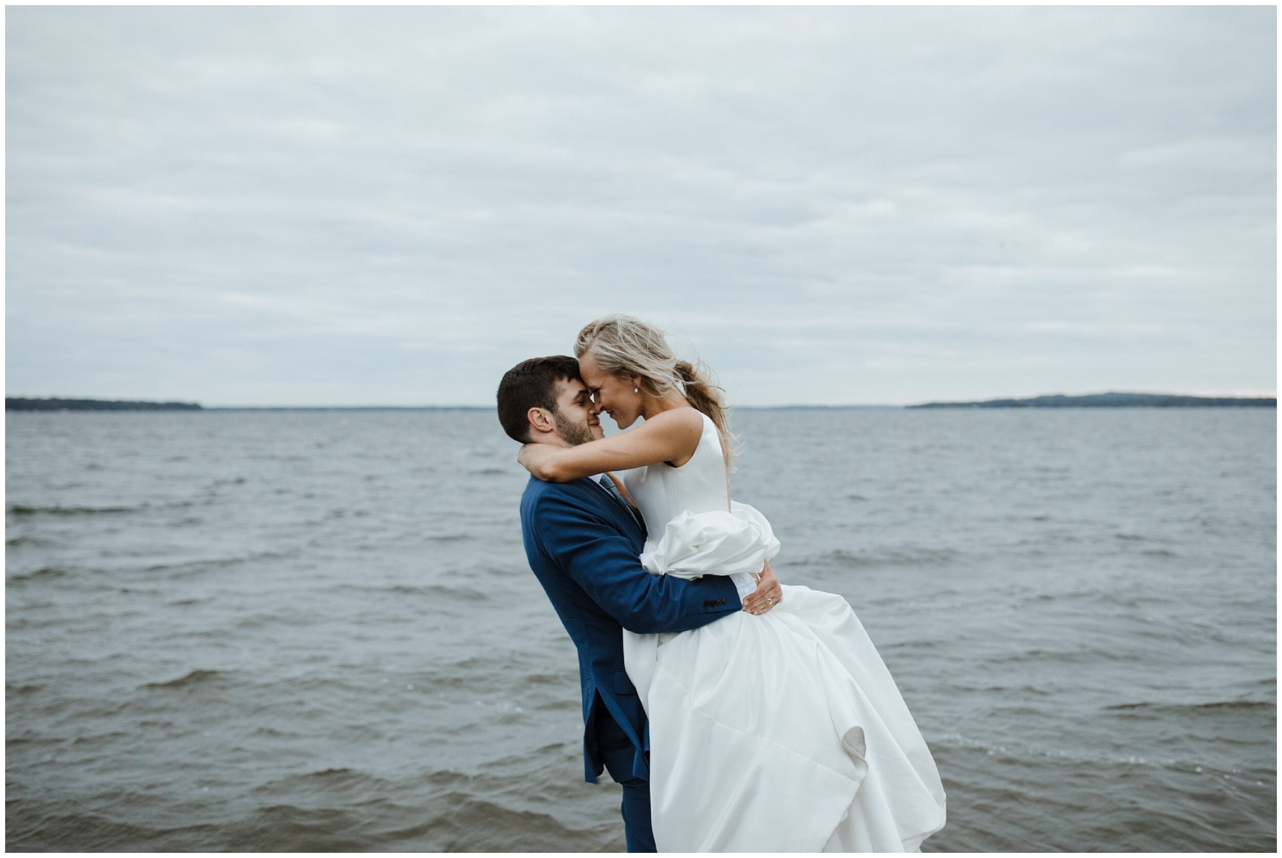 Groom lifting bride up and kissing her on Gull Lake beach during Grand View Lodge wedding