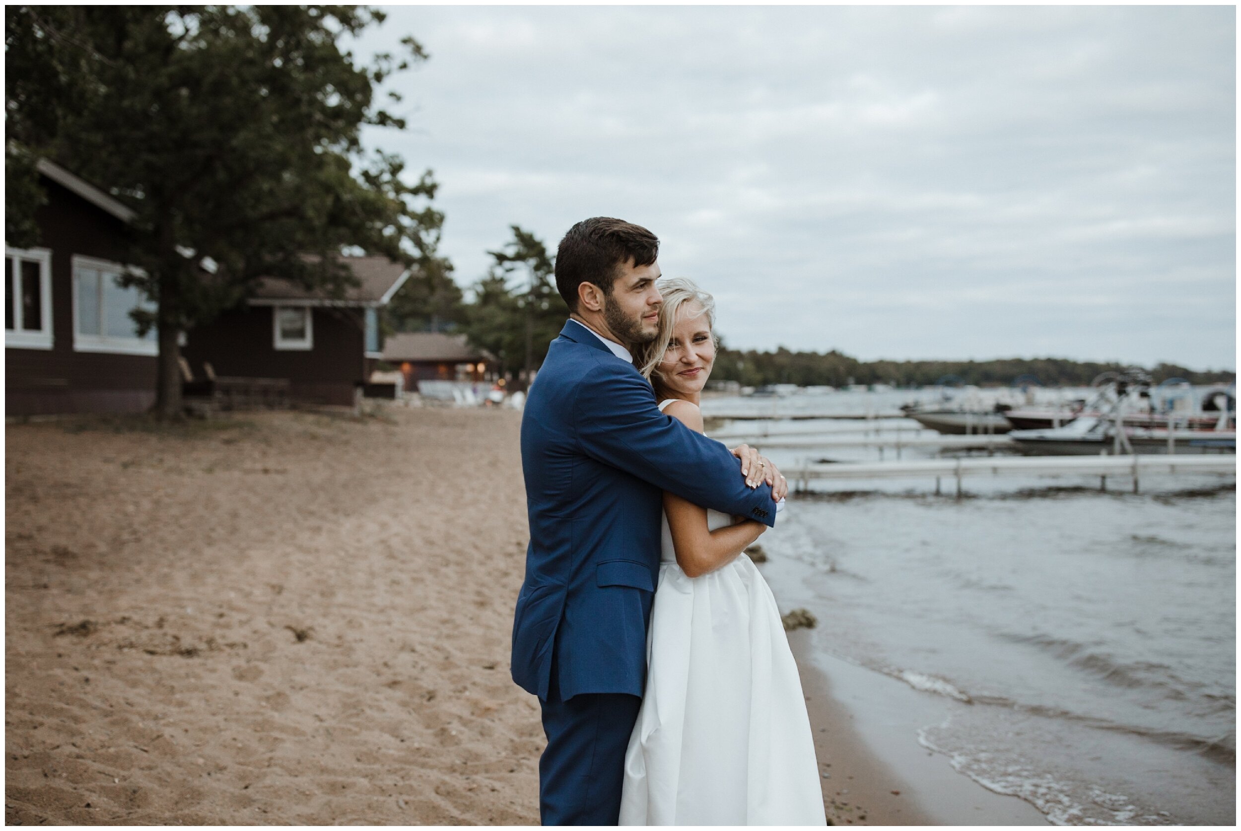 Groom hugging bride on gull lake beach at Grand View Lodge wedding