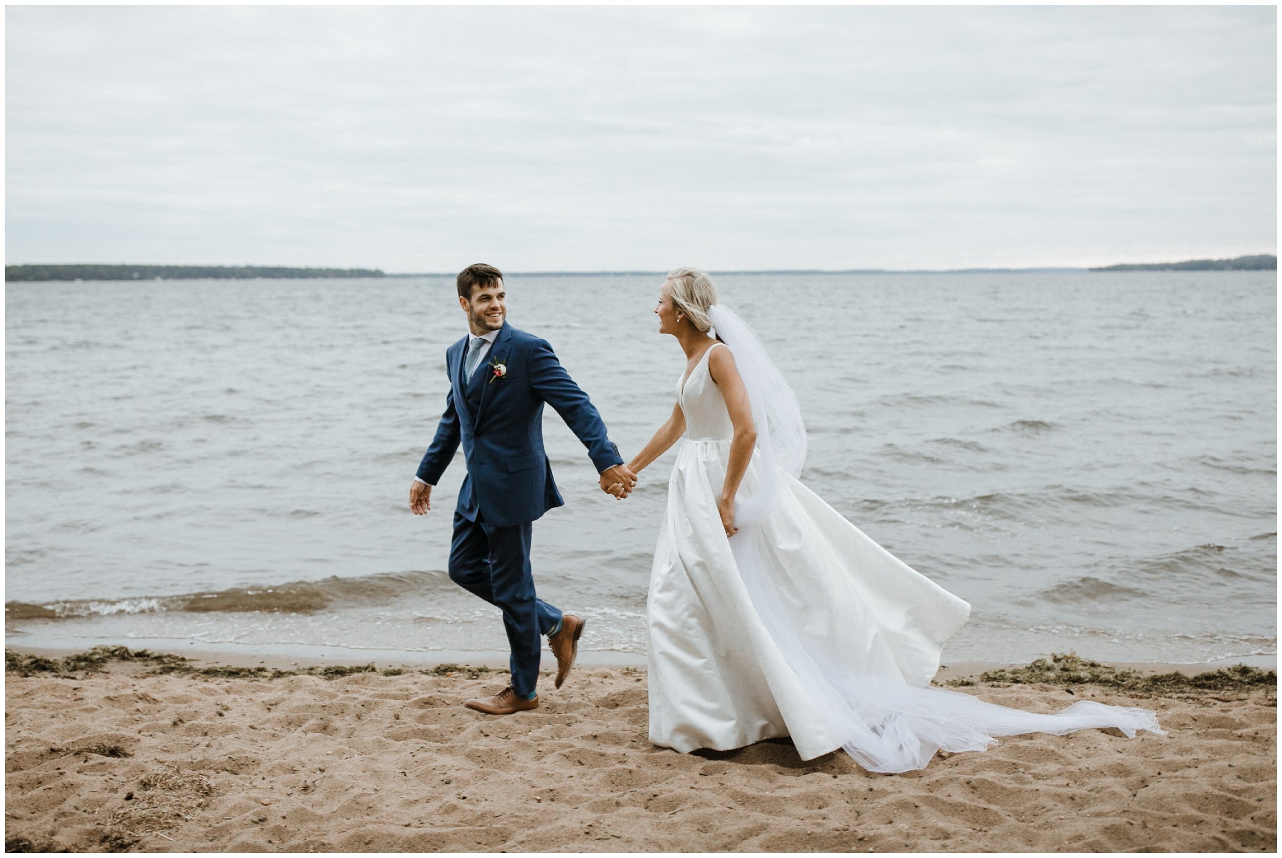 Bride and groom walking on Gull Lake sandy beach at Grand View Lodge wedding in Nisswa, Minnesota
