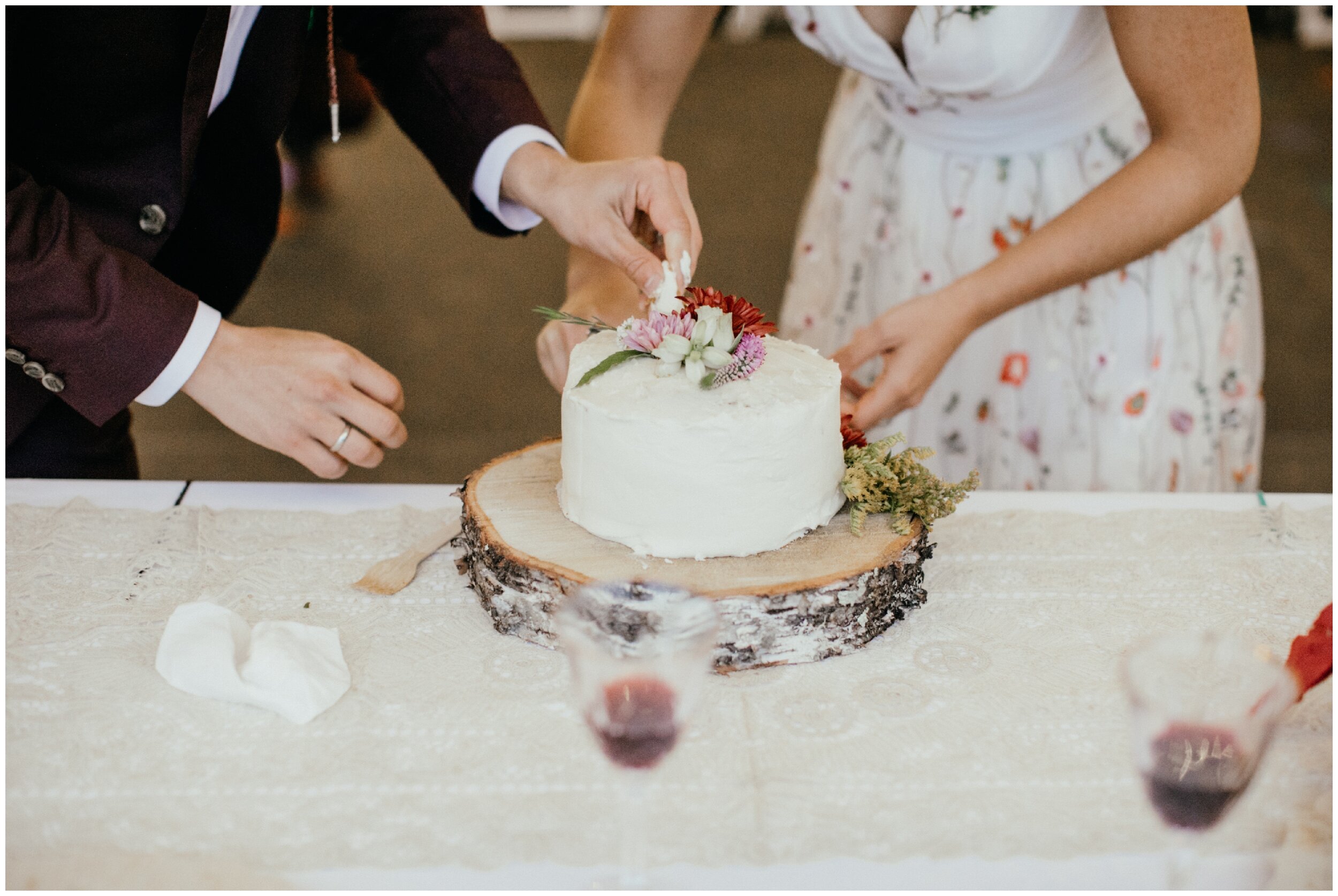 Bride and groom cut the cake at boho summer camp wedding in northern Minnesota