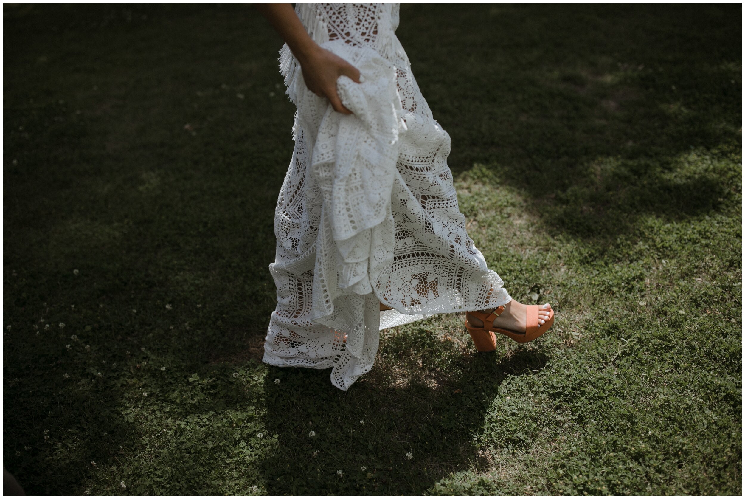 Bride walking in rue de seine dress to bohemian inspired Minnesota backyard wedding