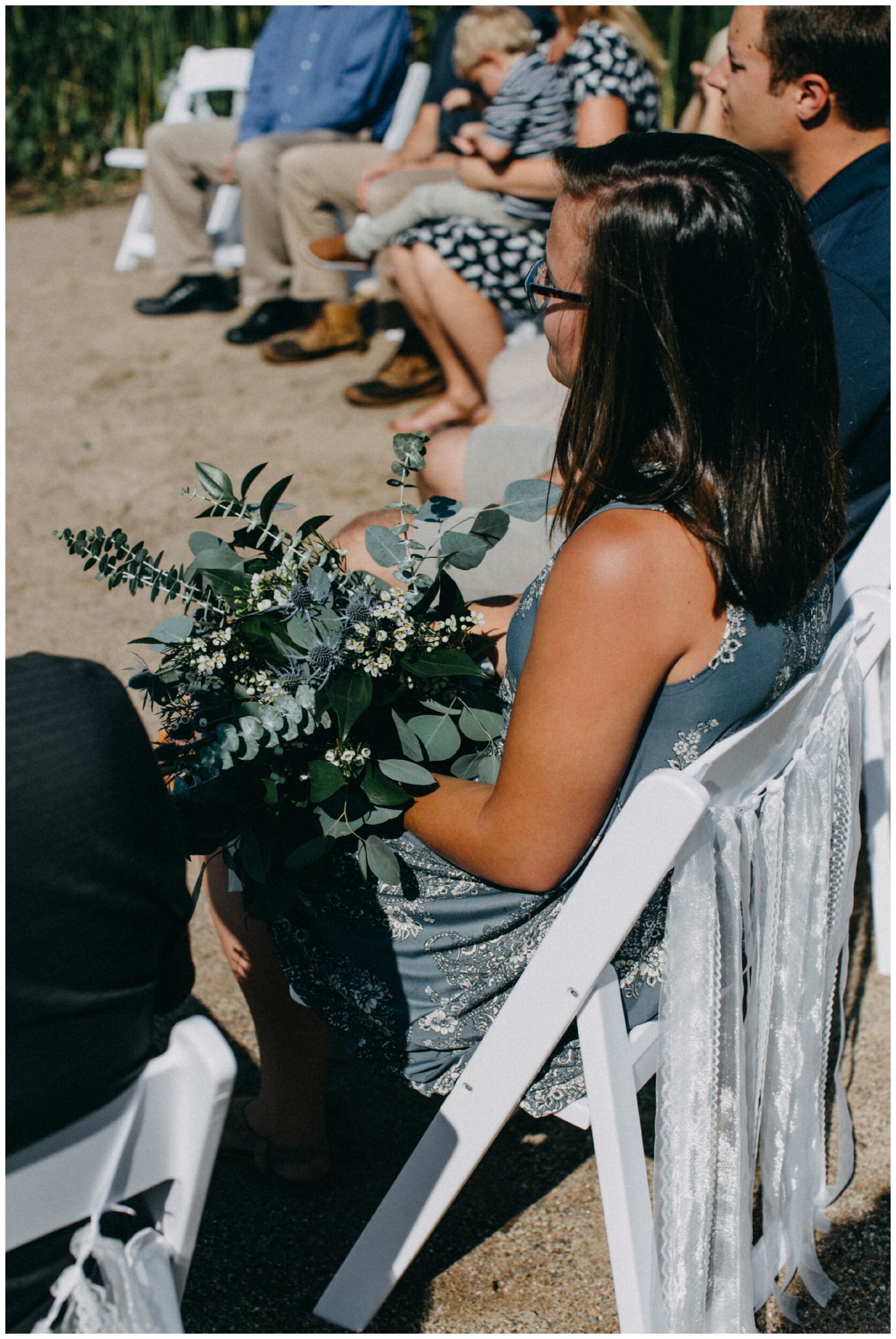 Eucalyptus and lace ceremony decor at intimate lakeside wedding ceremony on beach in Brainerd, Minnesota