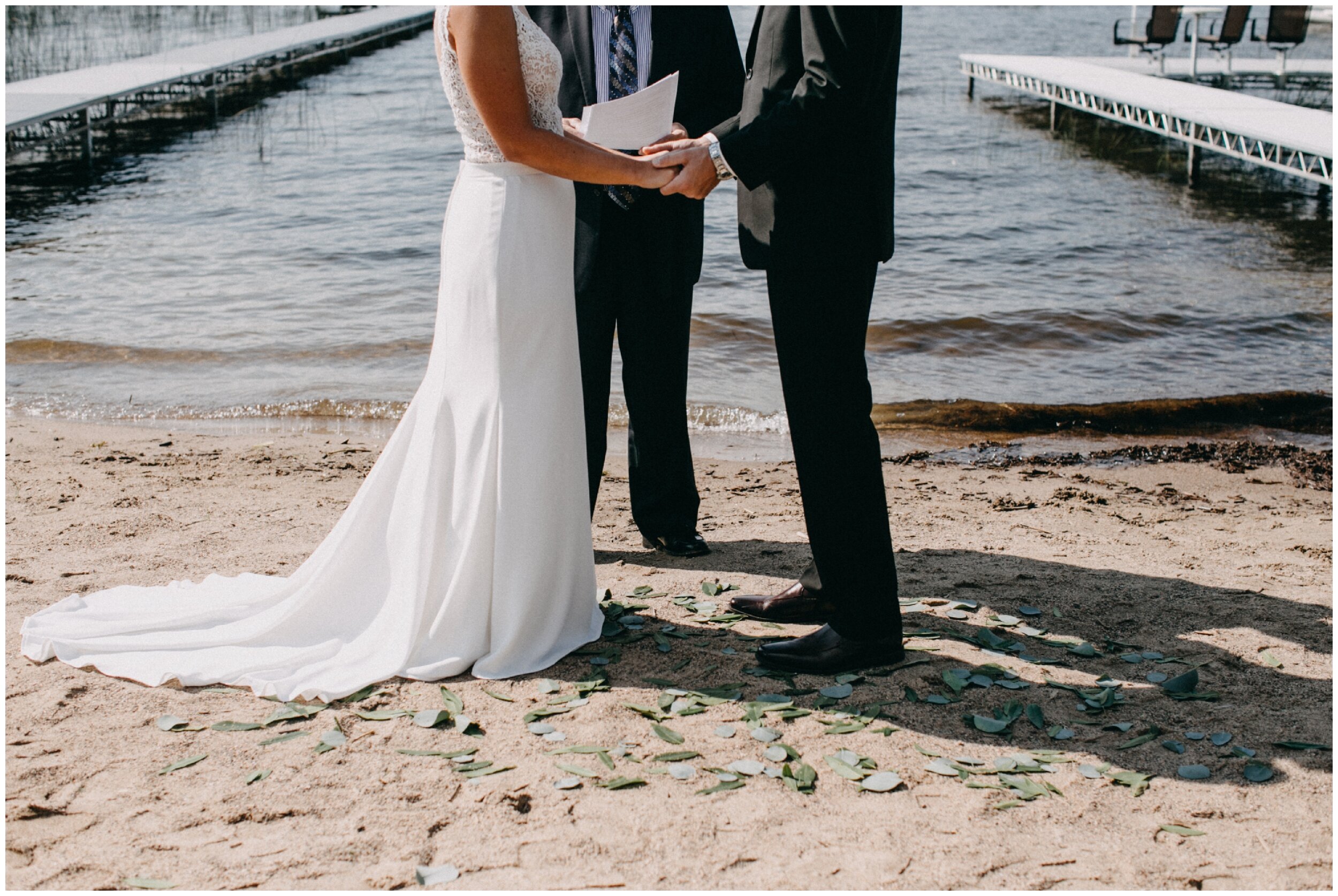 Bride and groom standing on sandy beach on Lake Edward in Brainerd, Minnesota
