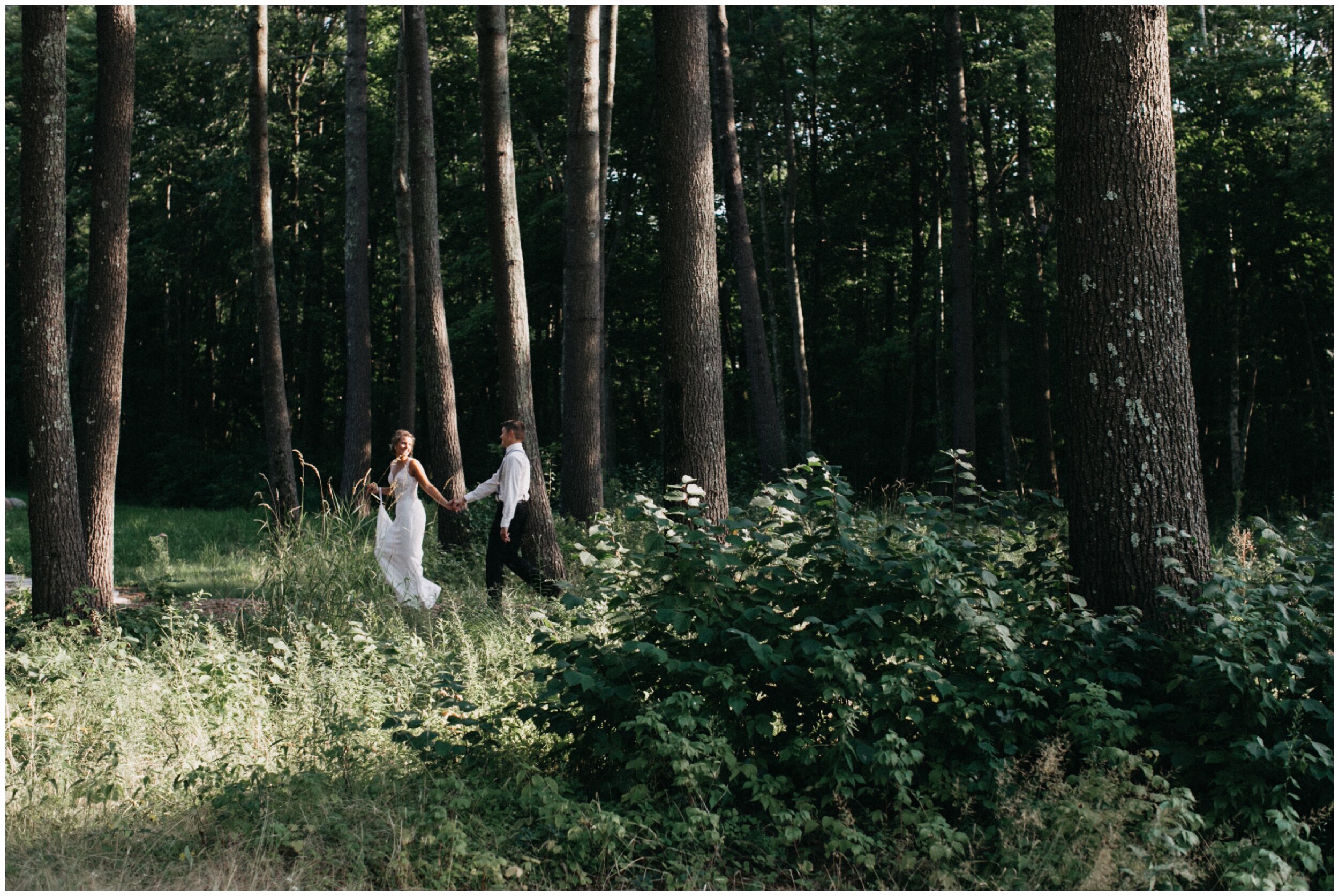 Bride and groom walking in woods at Brainerd Minnesota cabin wedding