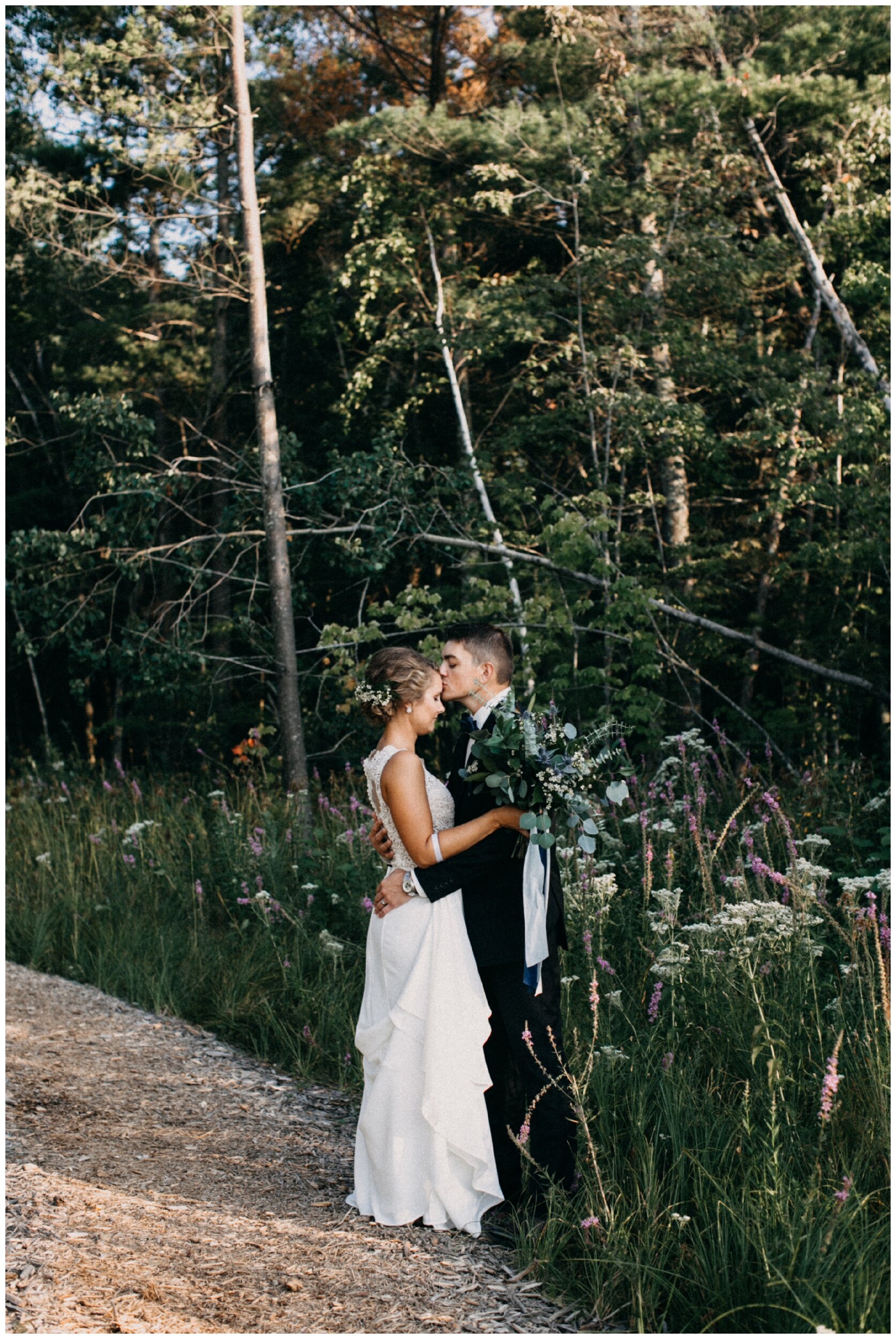 Groom kissing brides forehead at Brainerd, Minnesota cabin wedding