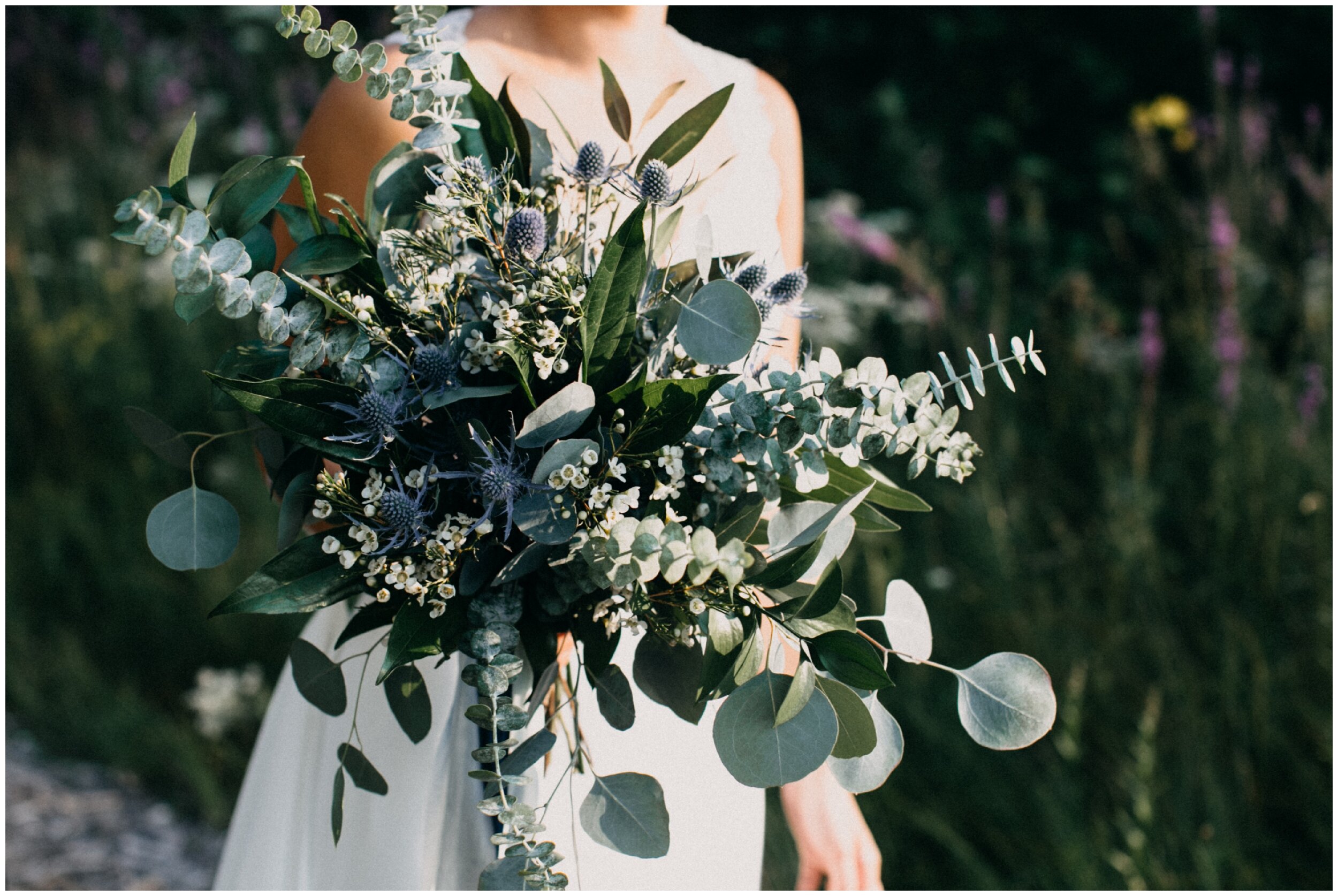 Bride holding eucalyptus bouquet at intimate Minnesota lakeside cottage wedding 