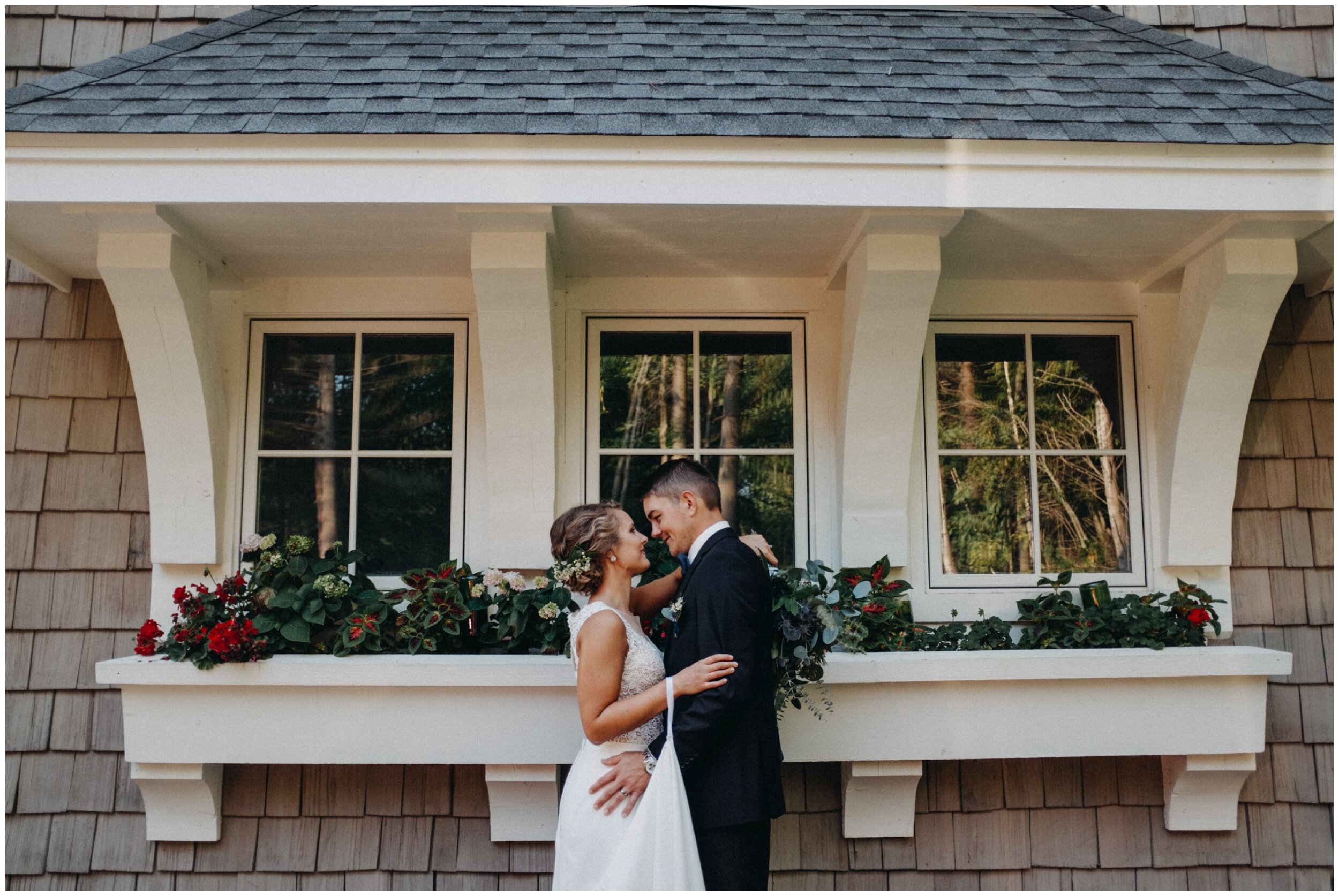 Bride and groom kissing in front of Lake Edward Cottage in Brainerd, Minnesota