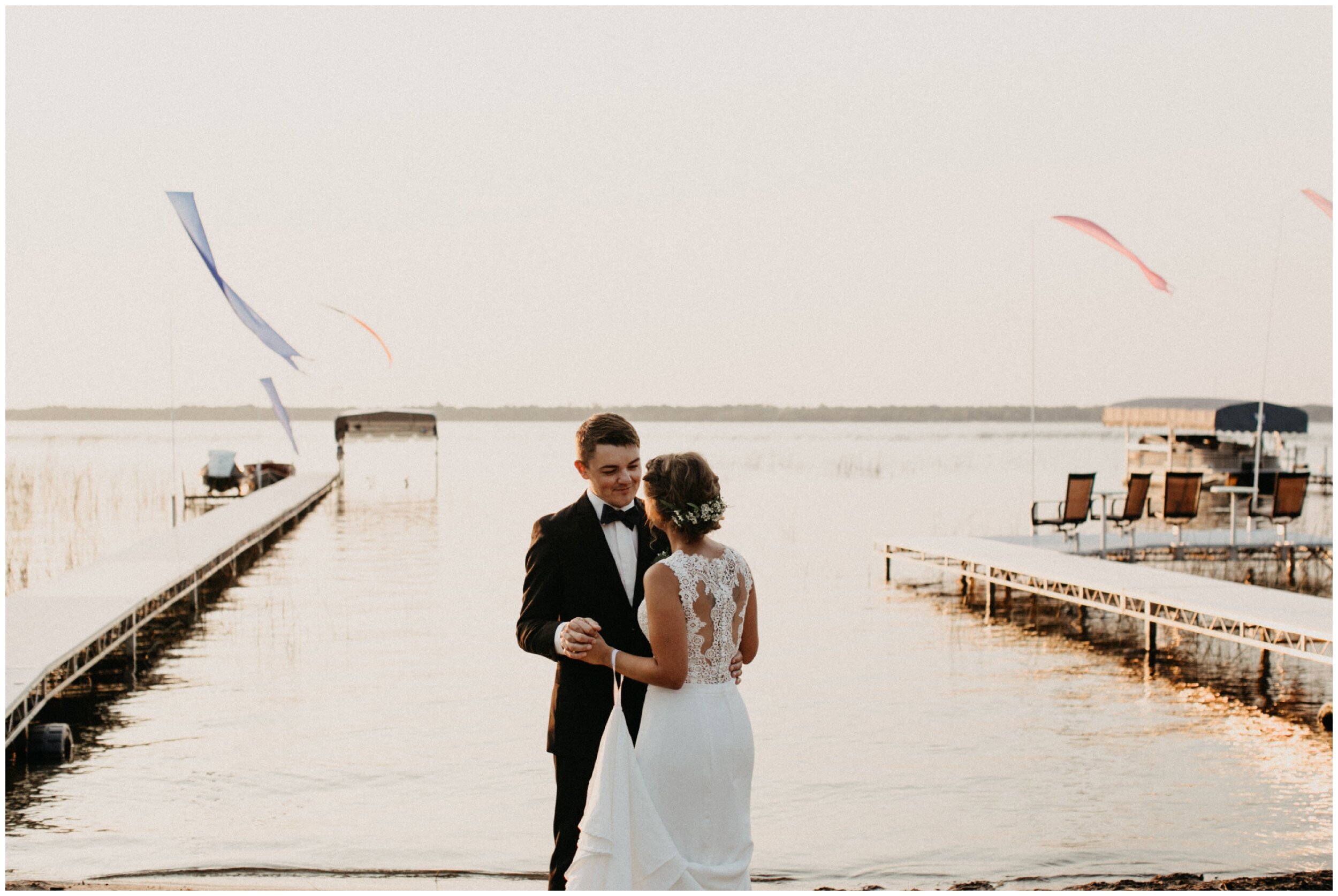 Bride and groom dancing by lake during sunset in Brainerd, Minnesota