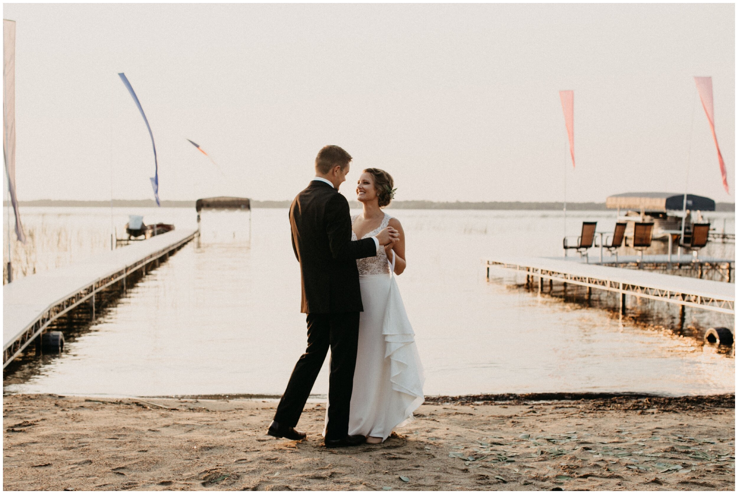 Bride and groom dancing on sandy beach during Brainerd, Minnesota lakeside cabin wedding
