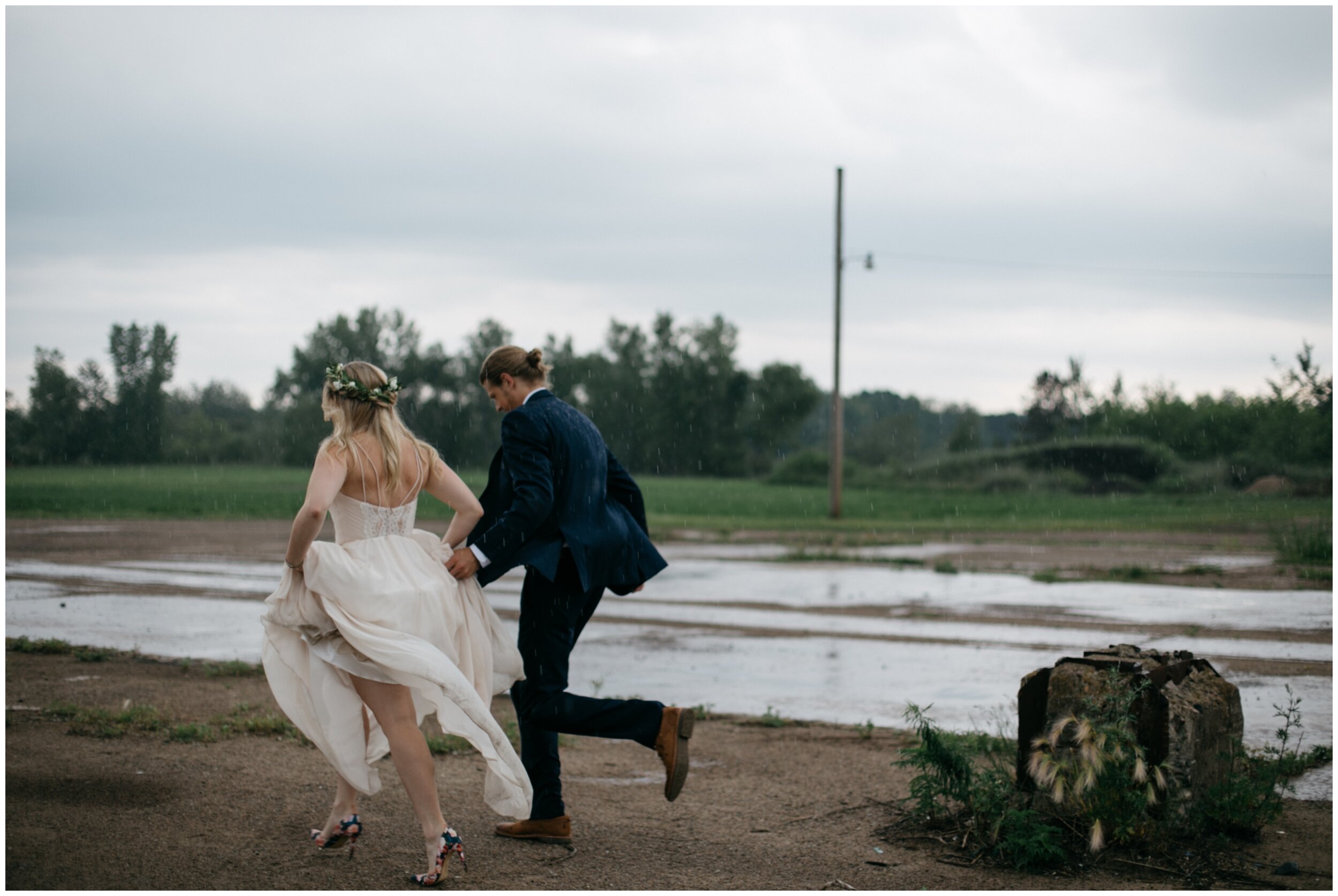 Bride and groom running in the rain outside romantic industrial wedding venue in Brainerd, Minnesota