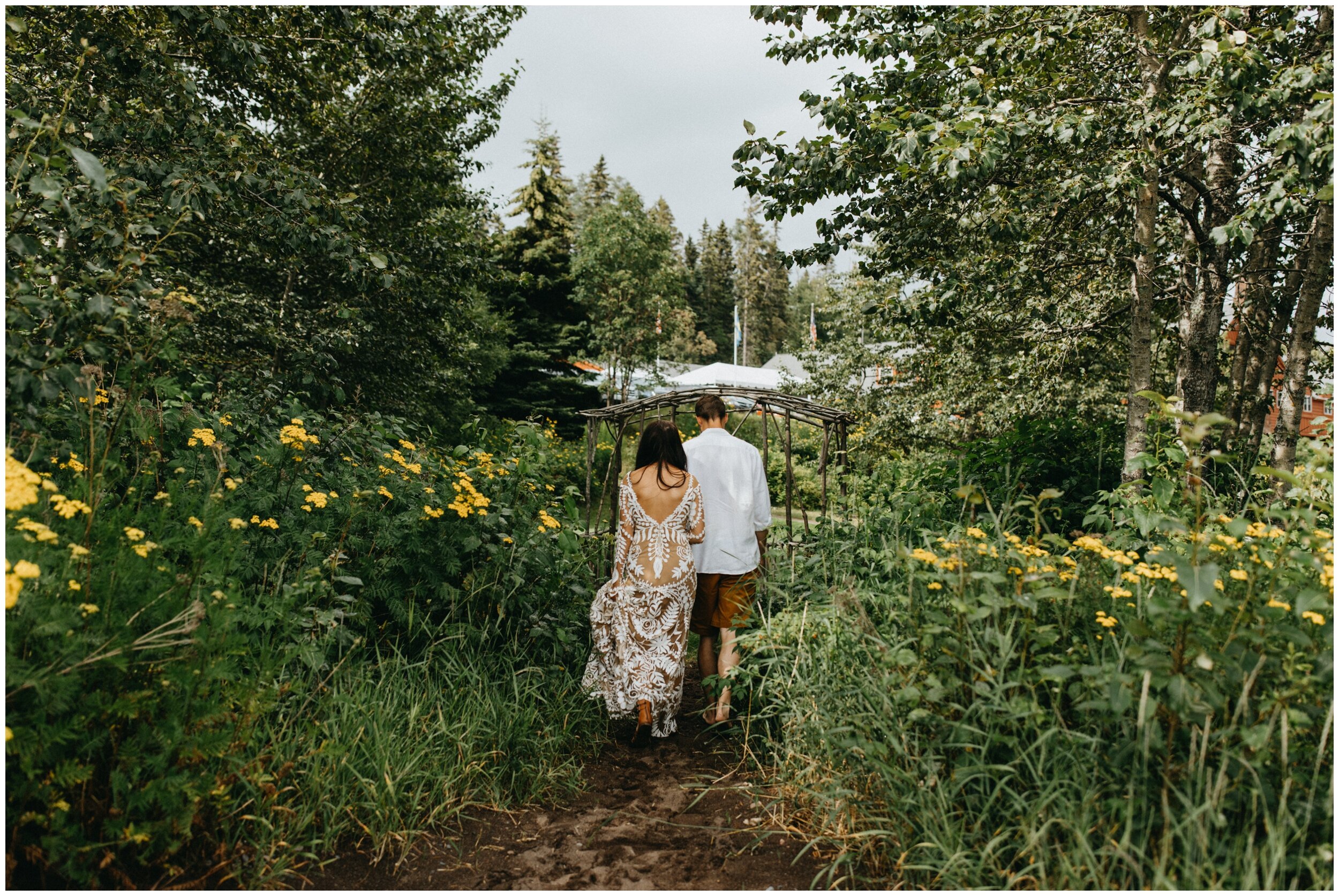 Bride and groom walking through wild flowers at Lutsen resort