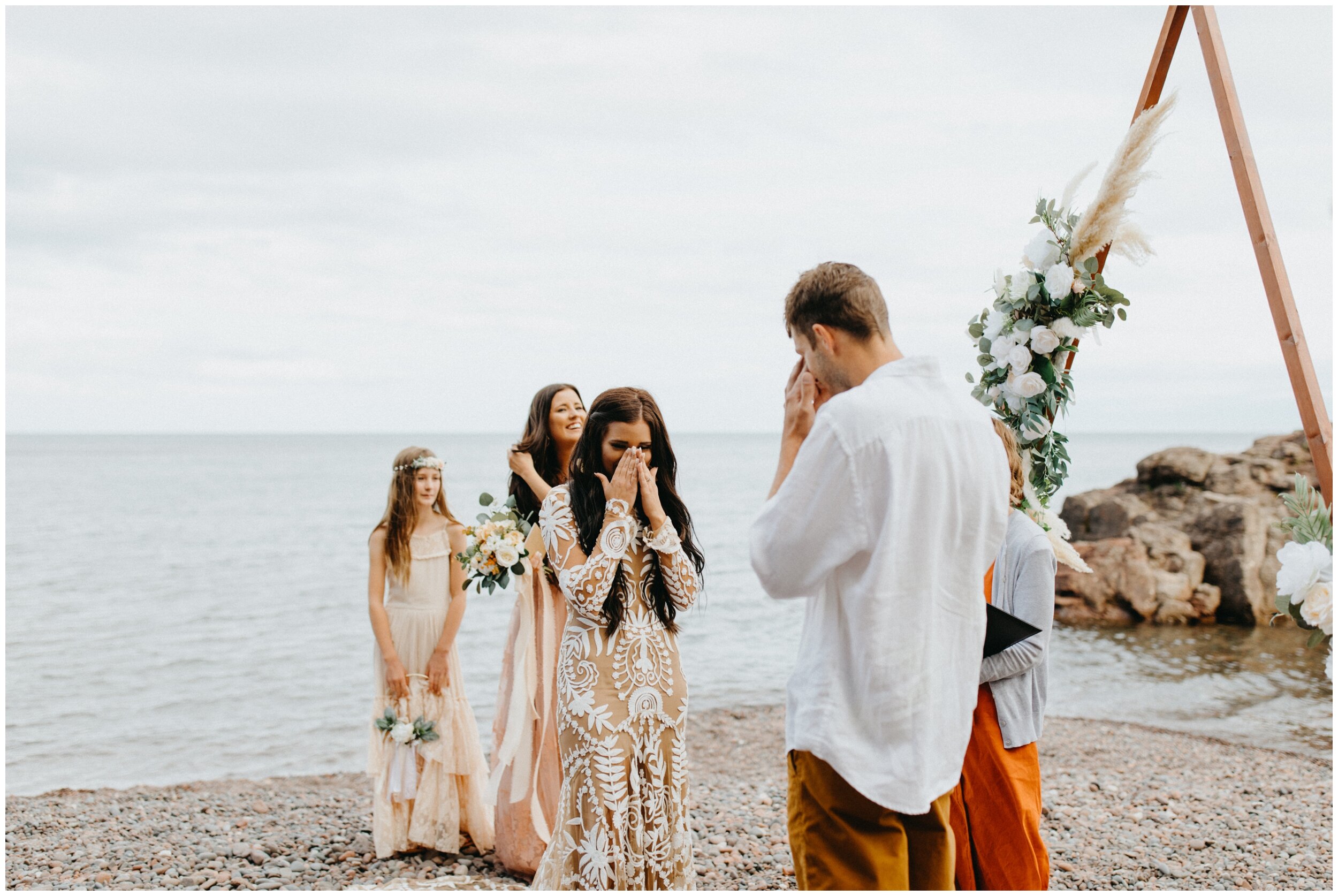 Bride and groom crying during wedding ceremony on the beach at Lutsen resort