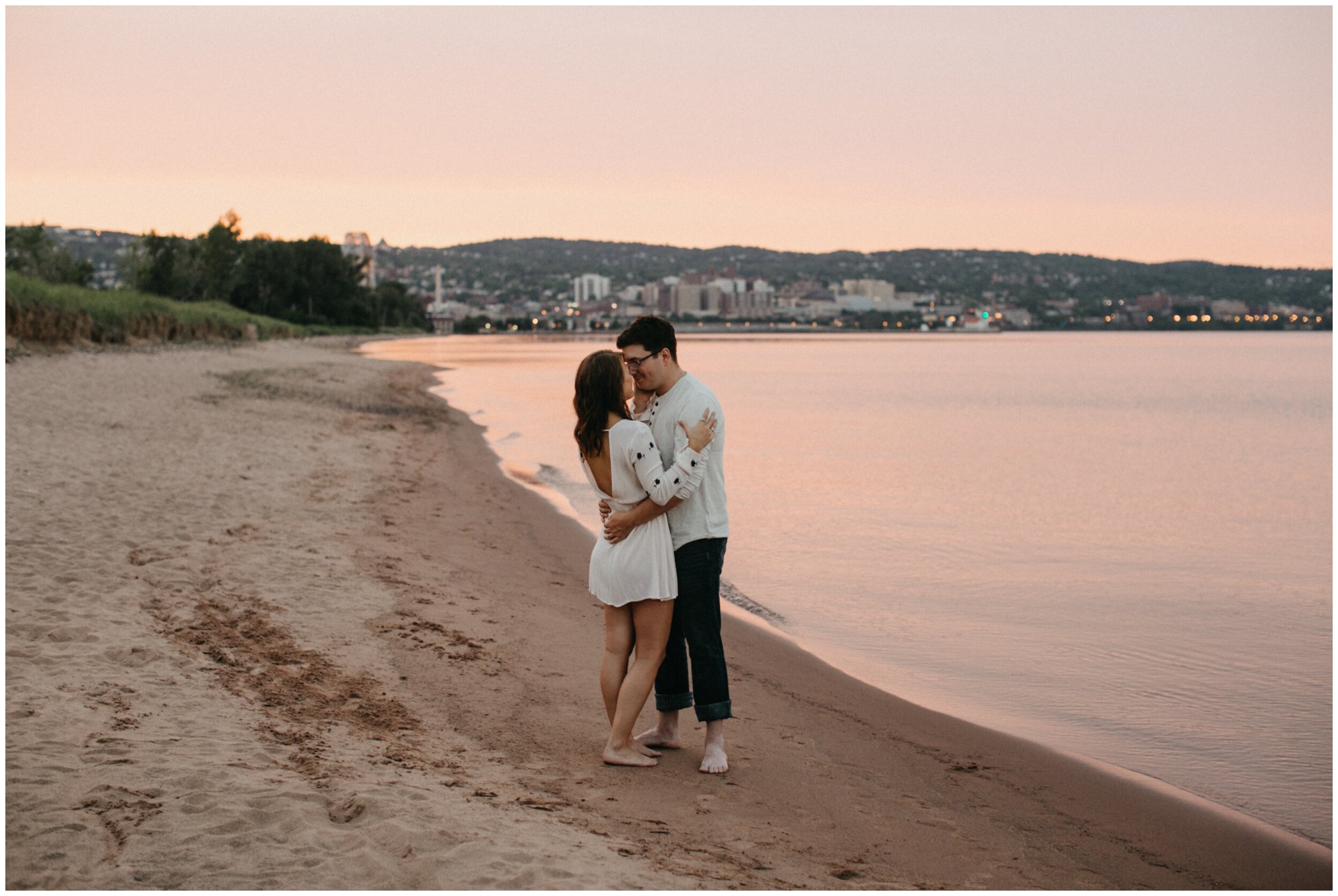 Couple kissing on beach during sunset at Park Point in Duluth, Minnesota