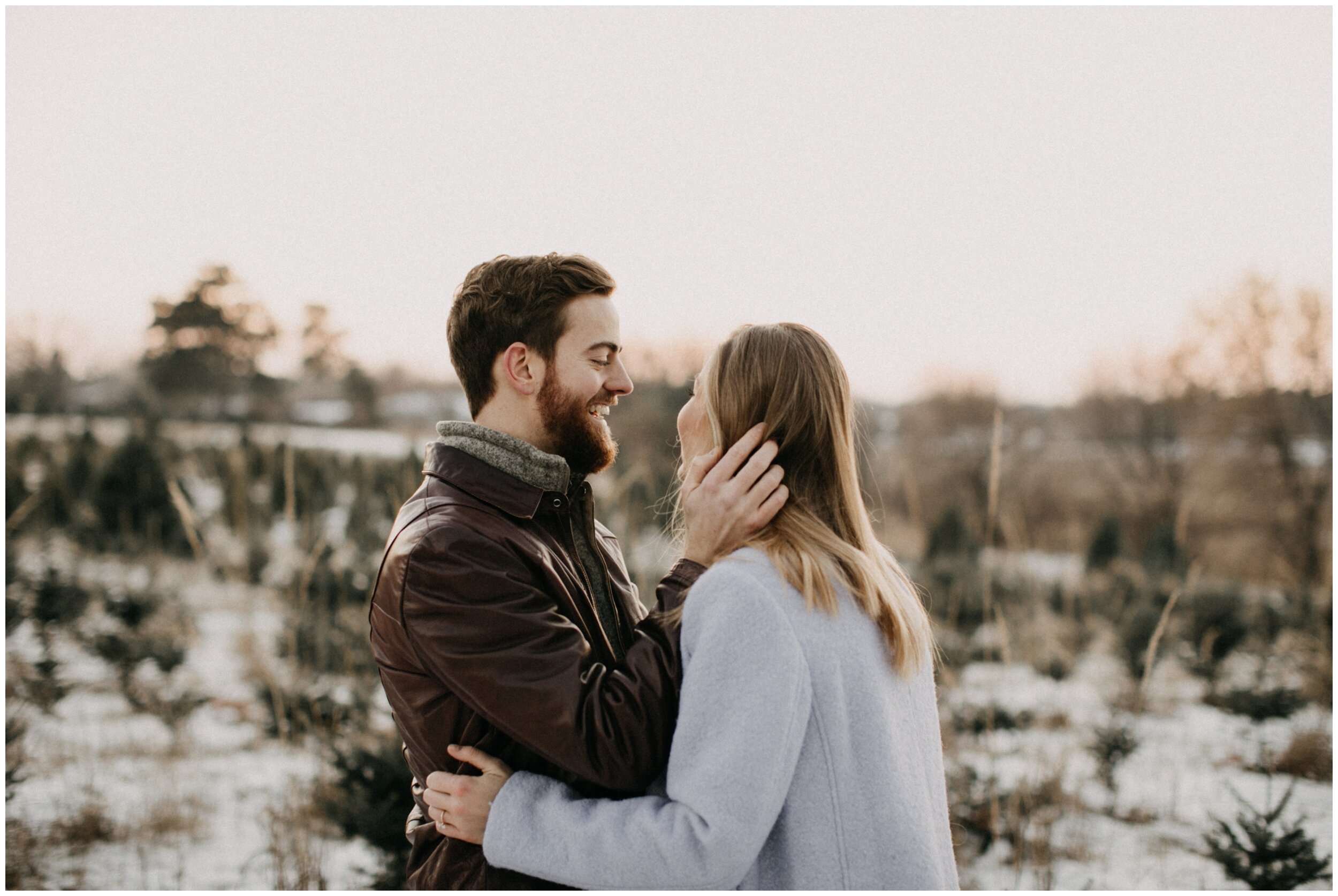 Couple laughing during engagement session at Minnesota Christmas tree farm