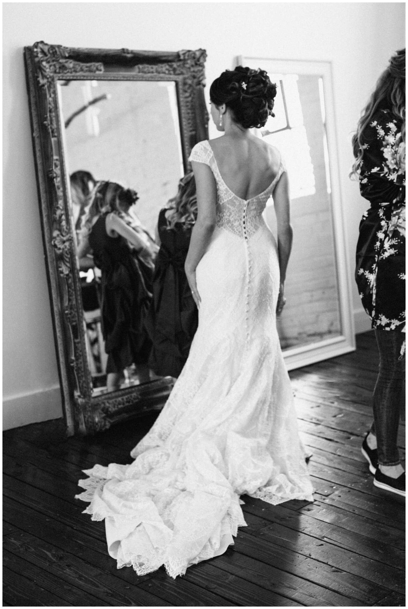 Bride looking in mirror while getting ready for wedding at Northern Pacific Center in Brainerd Minnesota