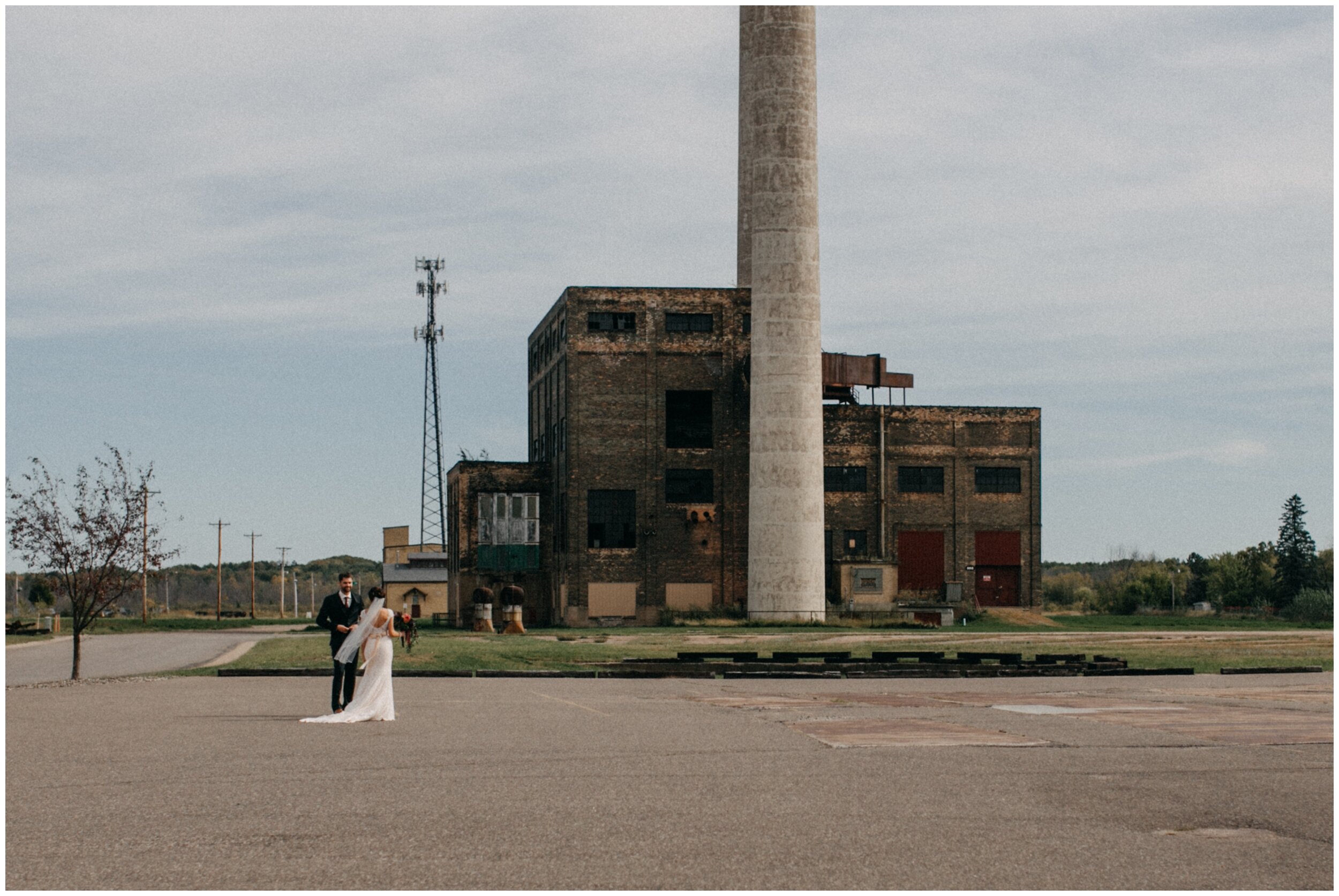 Bride and groom standing in front of power plant building at the Northern Pacific Center in Brainerd, Minnesota