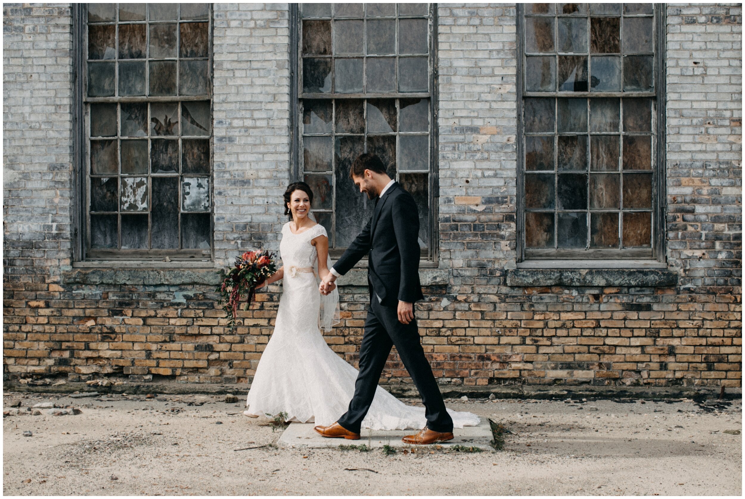 Bride and groom walking in front of industrial warehouse wedding venue at the Northern Pacific Center in Brainerd, Minnesota
