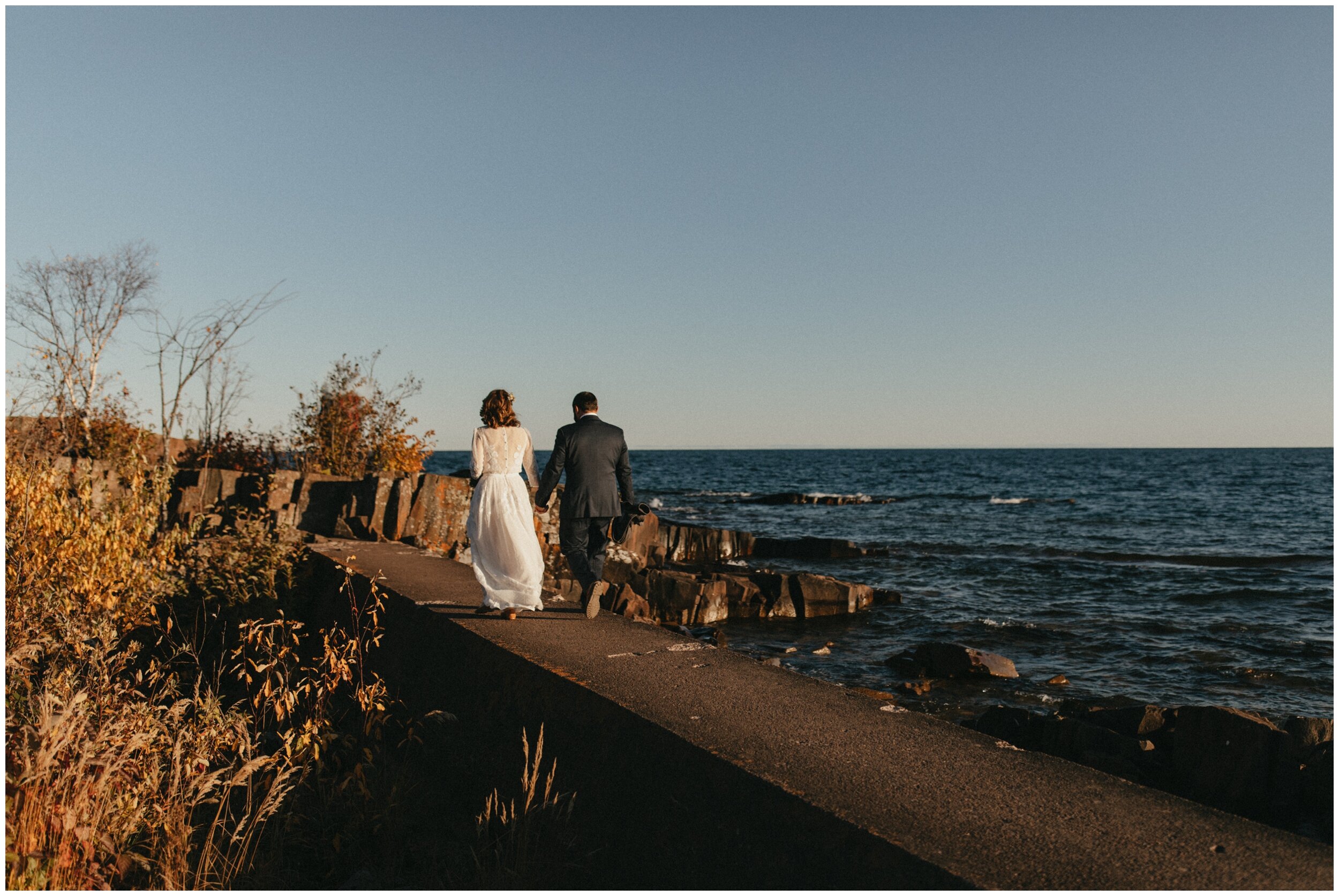 Bride and groom walking to wedding during sunset in Grand Marais, Minnesota