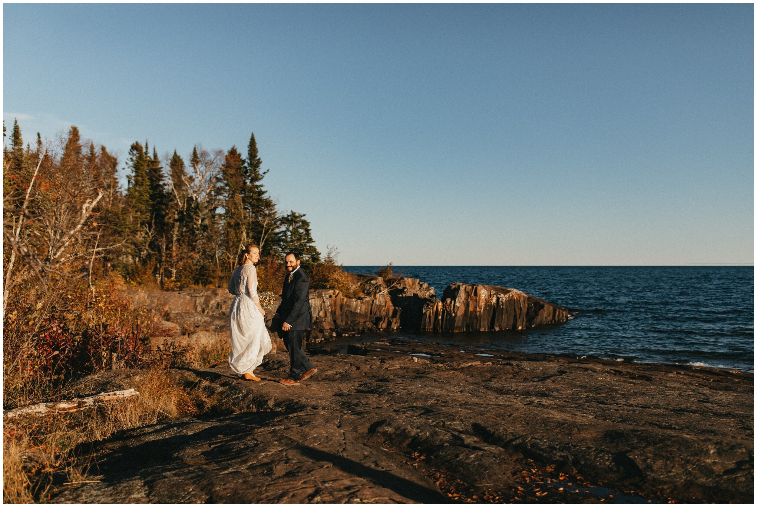 Bride and groom walking into woods on artists' point in Grand Marais, Minnesota