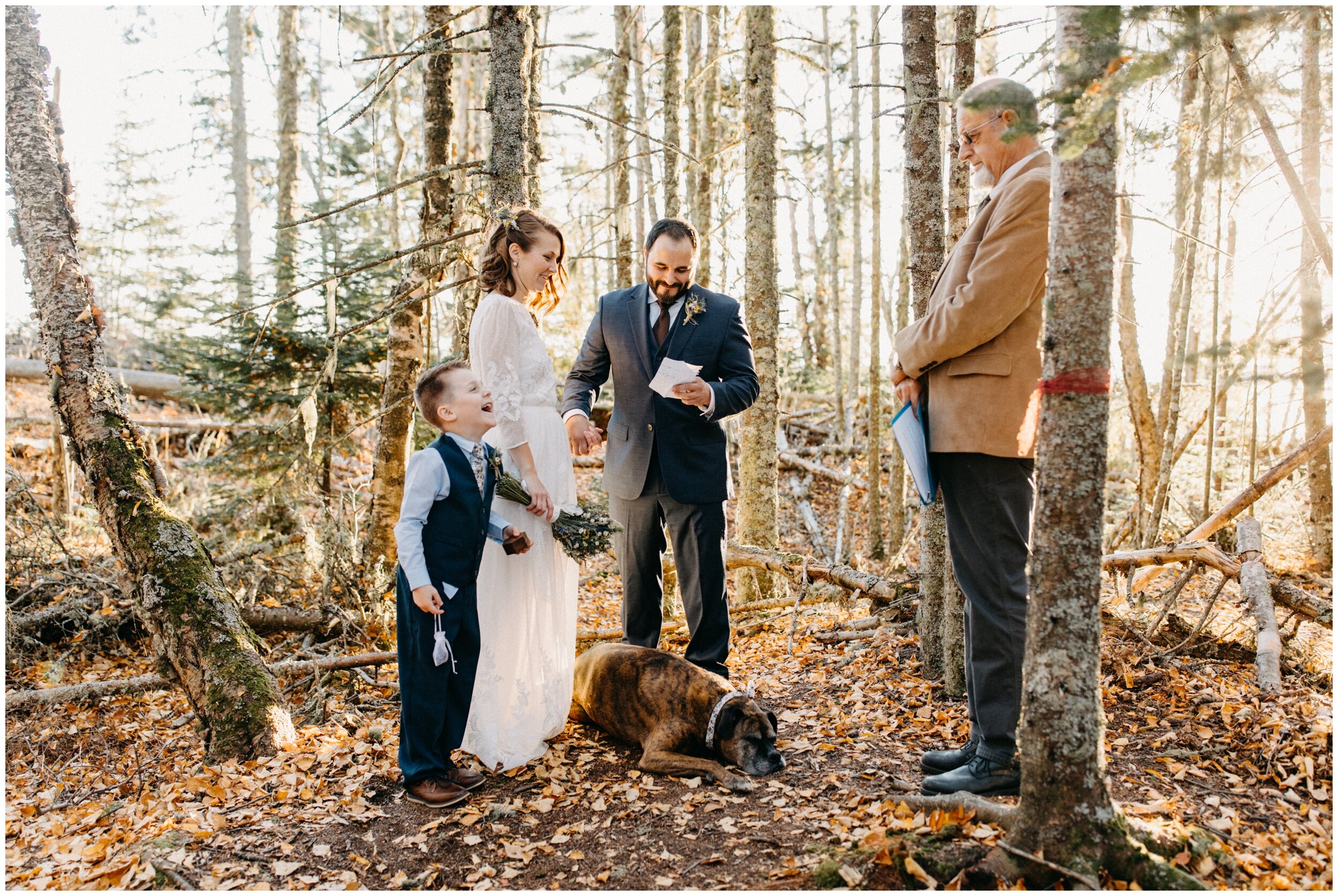 Groom reading wedding vows during intimate ceremony in the woods on Artists' Point