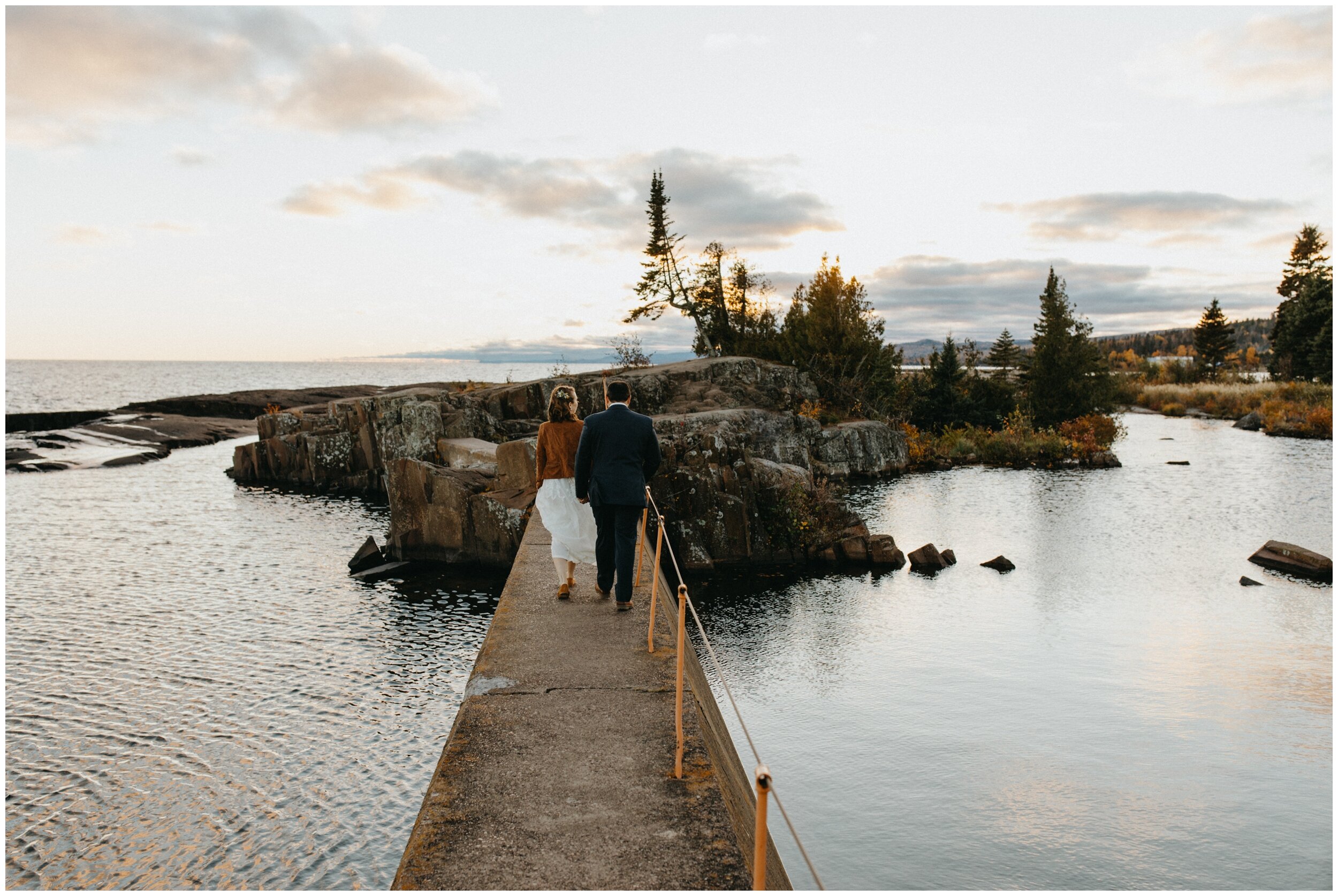 Bride and groom walking on Artists' Point after wedding in Grand Marais Minnesota