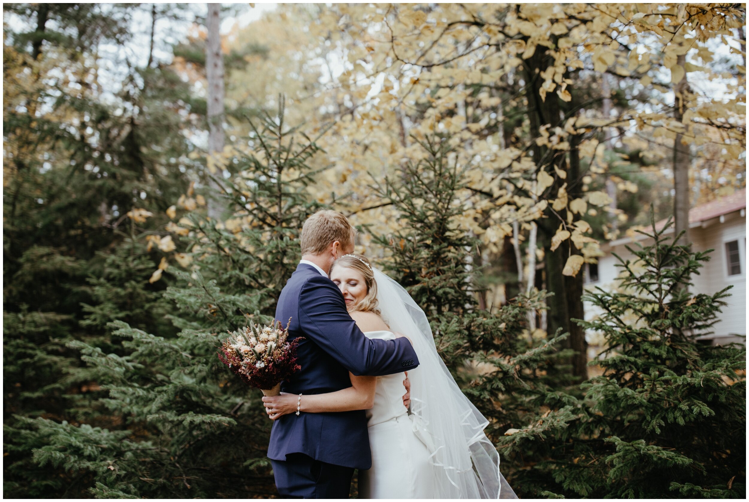 Bride and groom hugging at Minnesota fall summer camp wedding on Crosslake