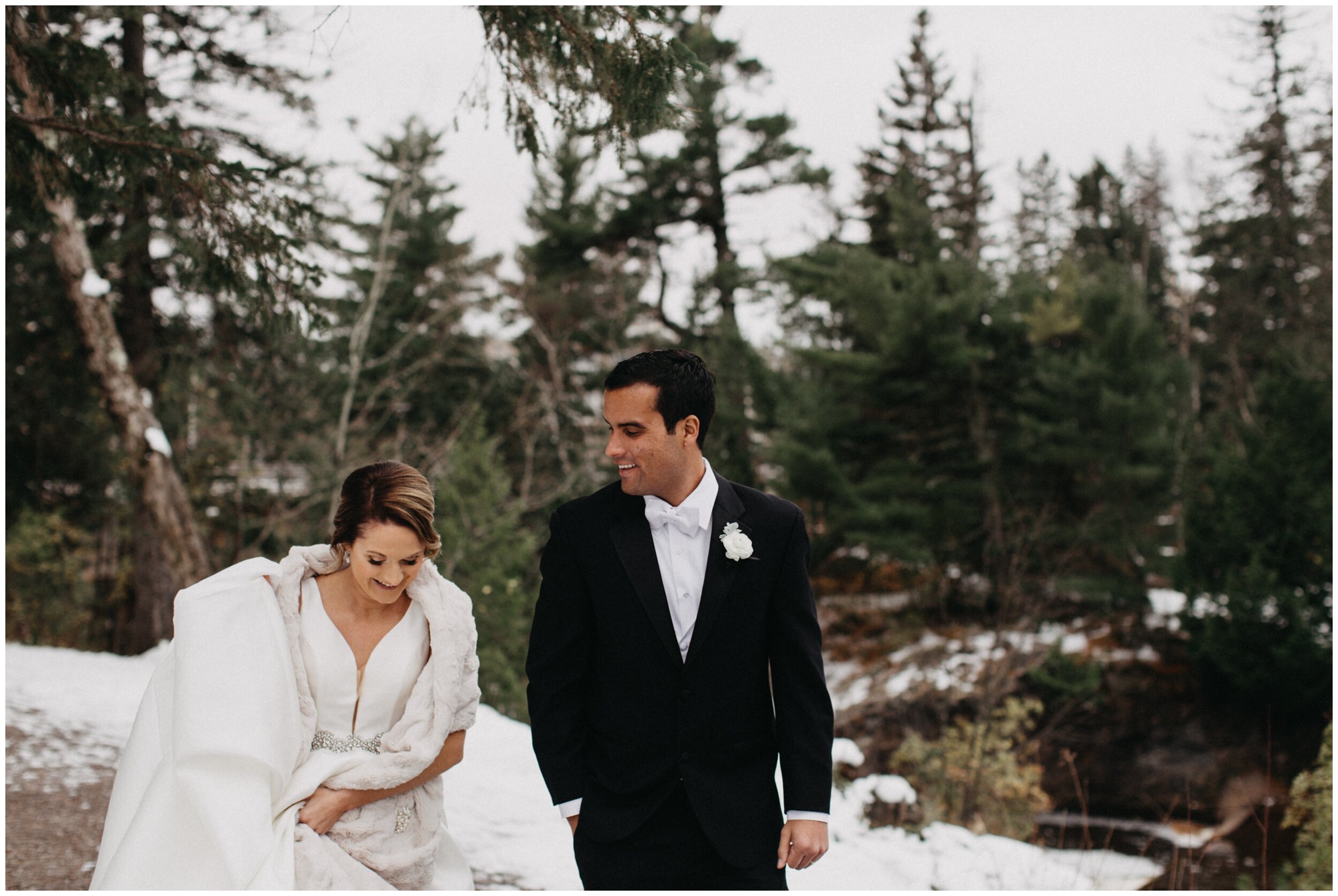 Bride and groom walking through snowy Lester Park in Duluth Minnesota