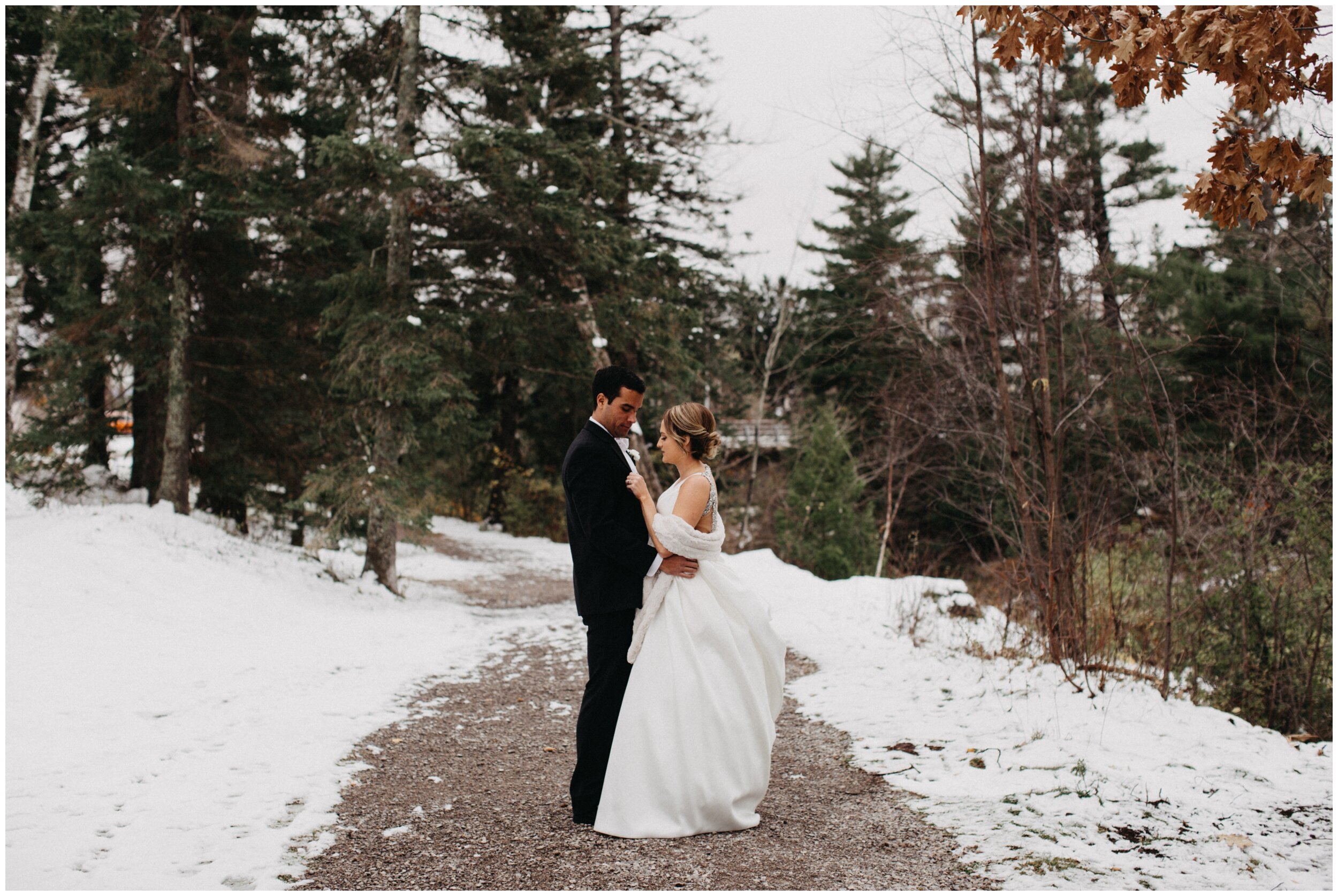 Bride and groom standing in snowy park in Duluth, Minnesota