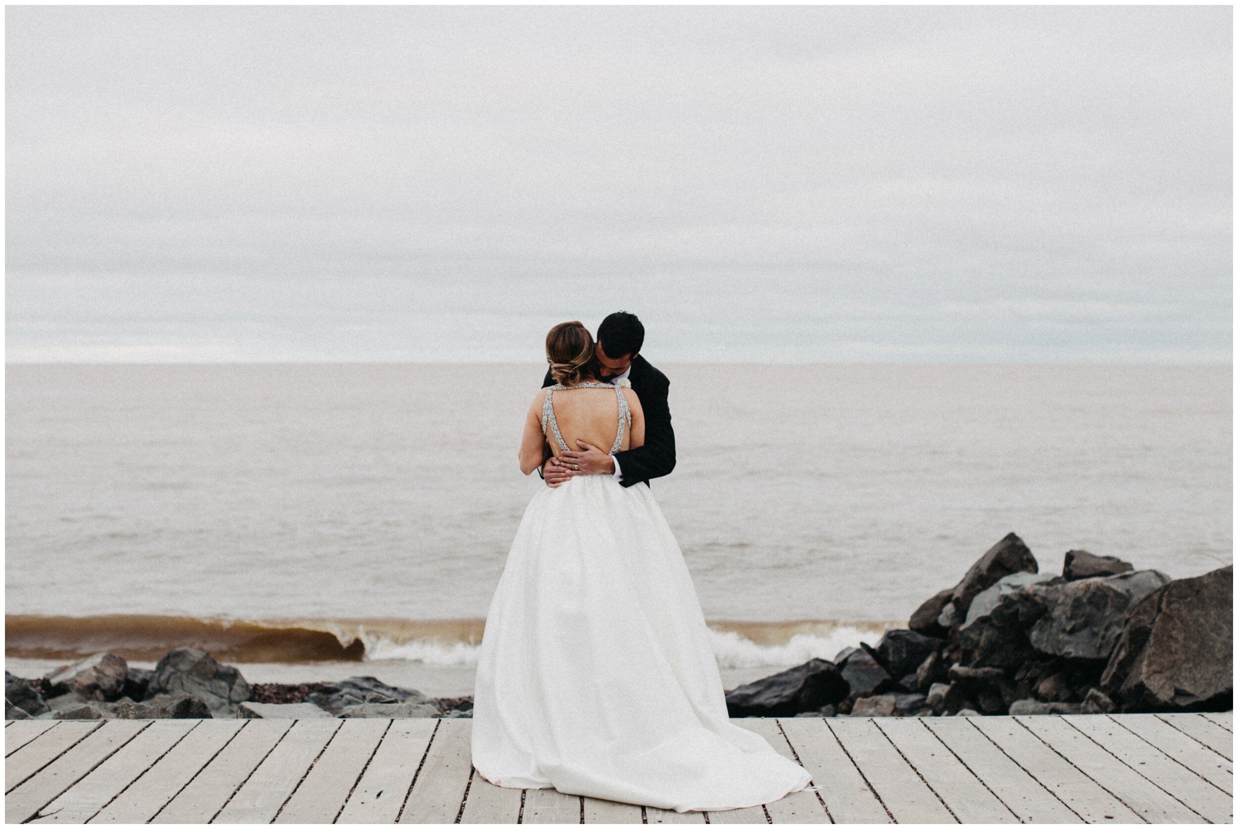 Bride and groom standing on canal park boardwalk in Duluth, Minnesota