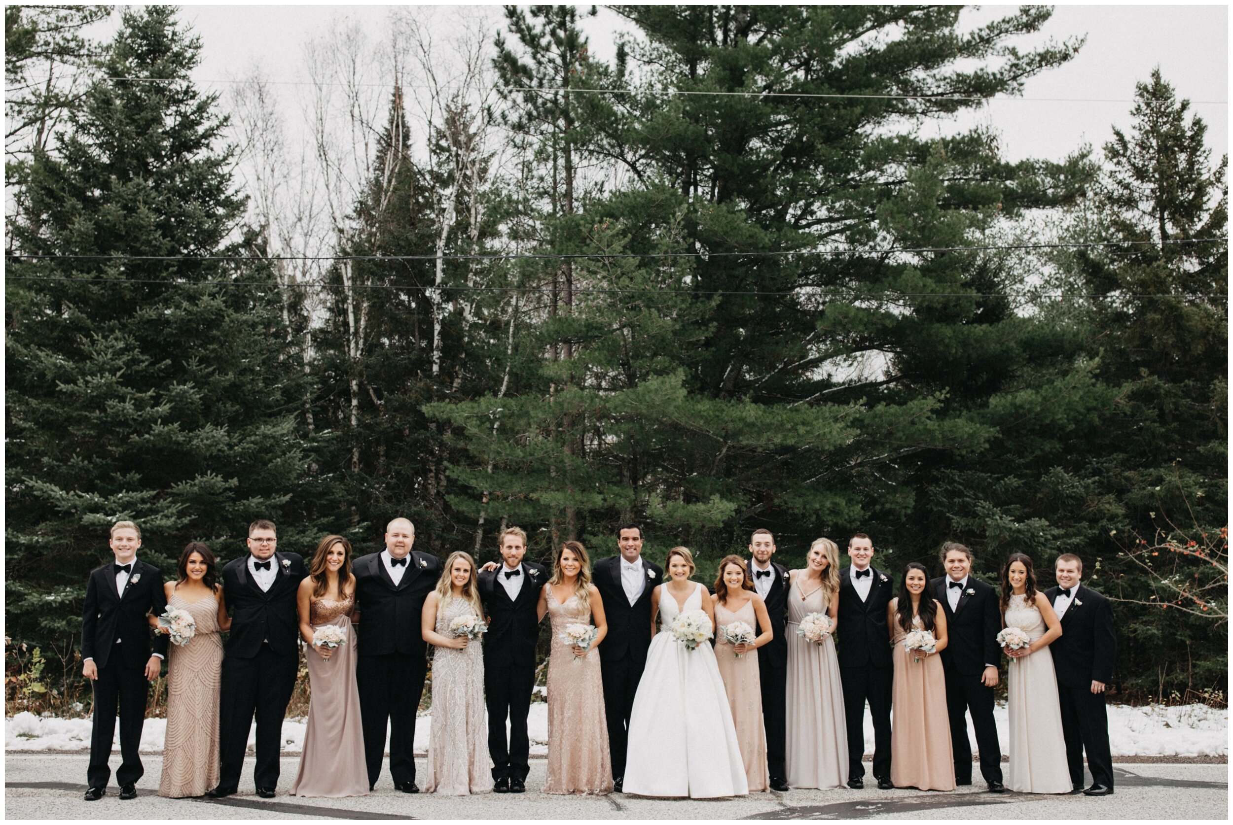Bride and groom with wedding party standing in front of pine trees in Duluth, Minnesota