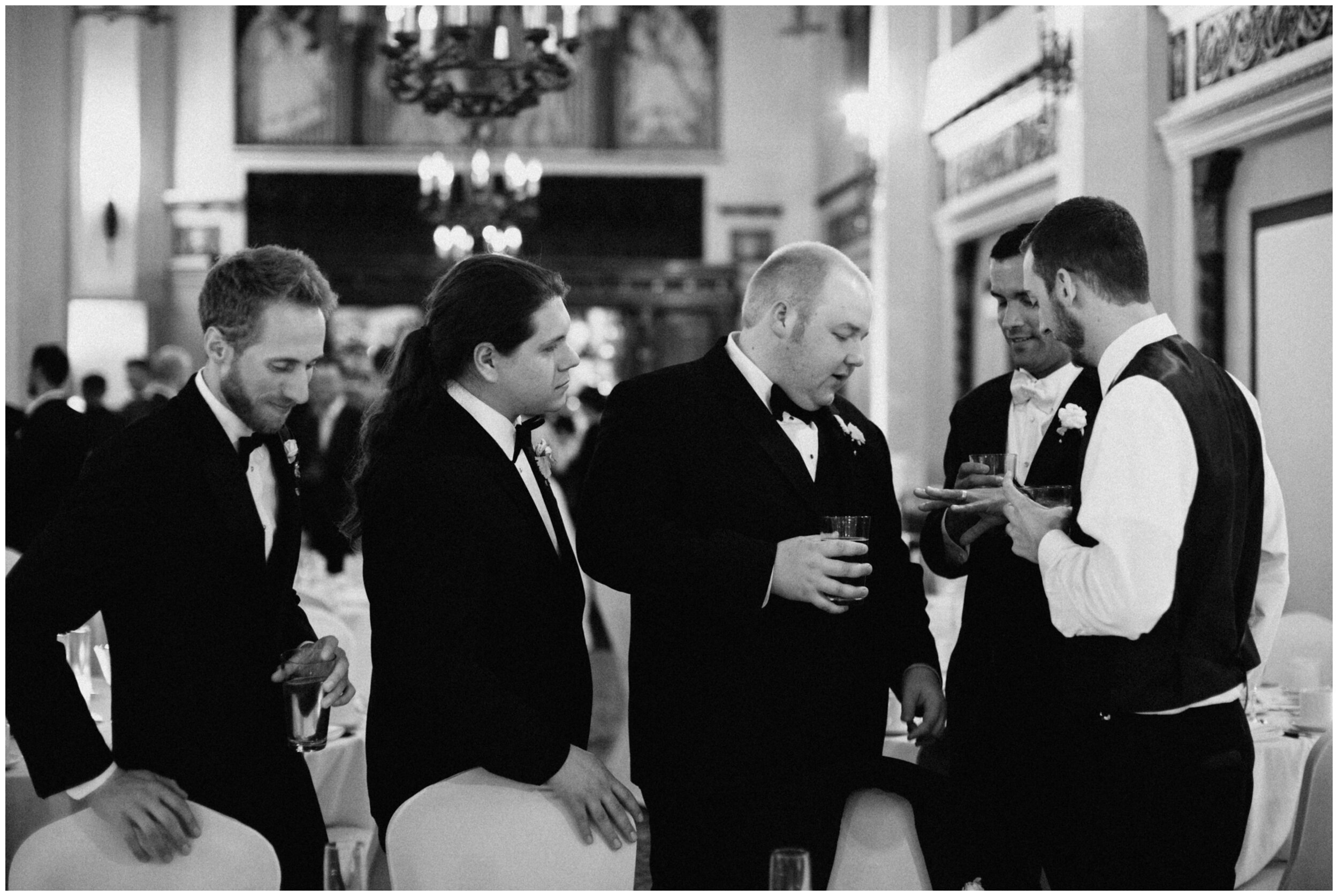 Groom showing off his wedding ring to his groomsmen at the Greysolon