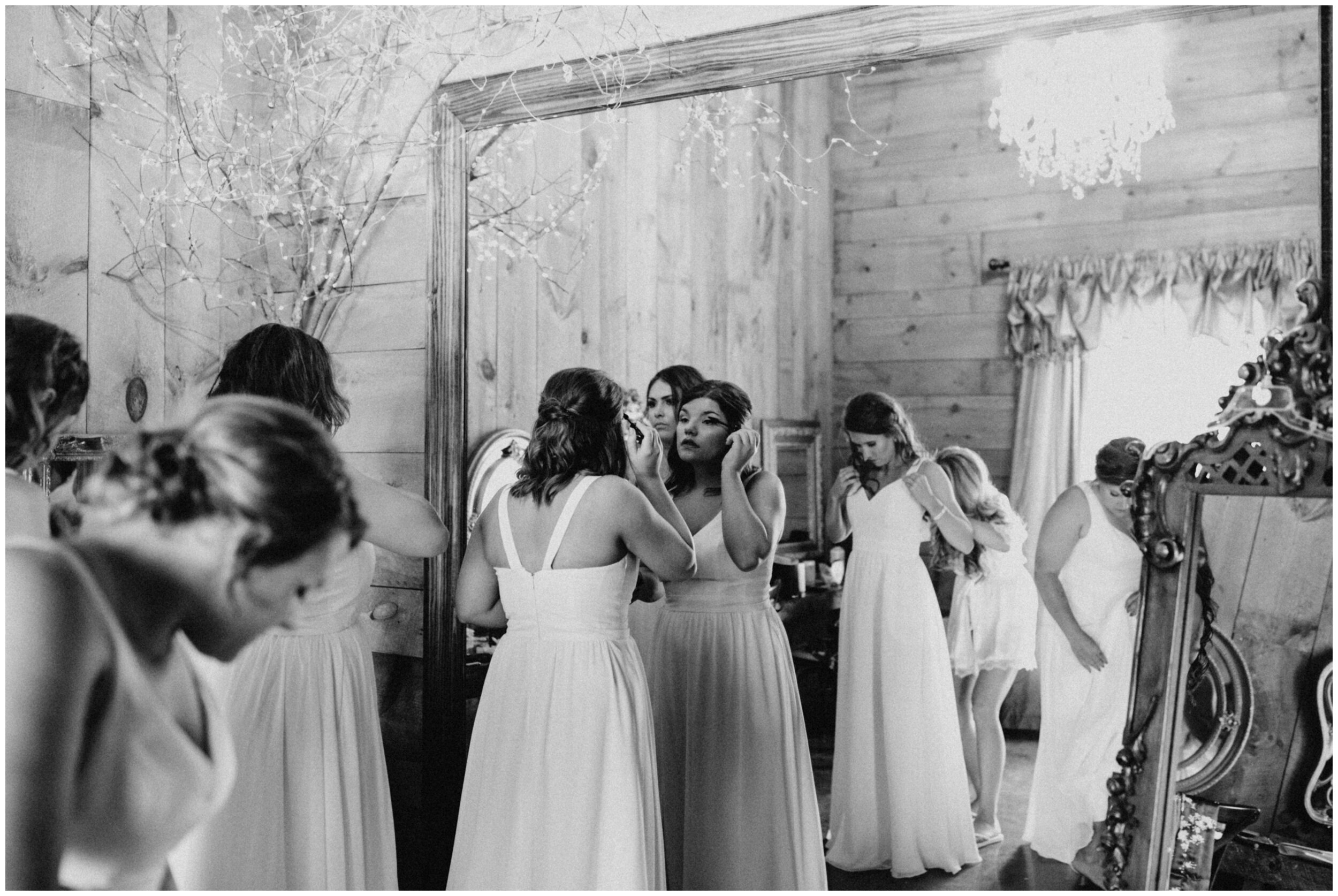 Bridesmaids getting into white dresses for barn wedding at Creekside Farm