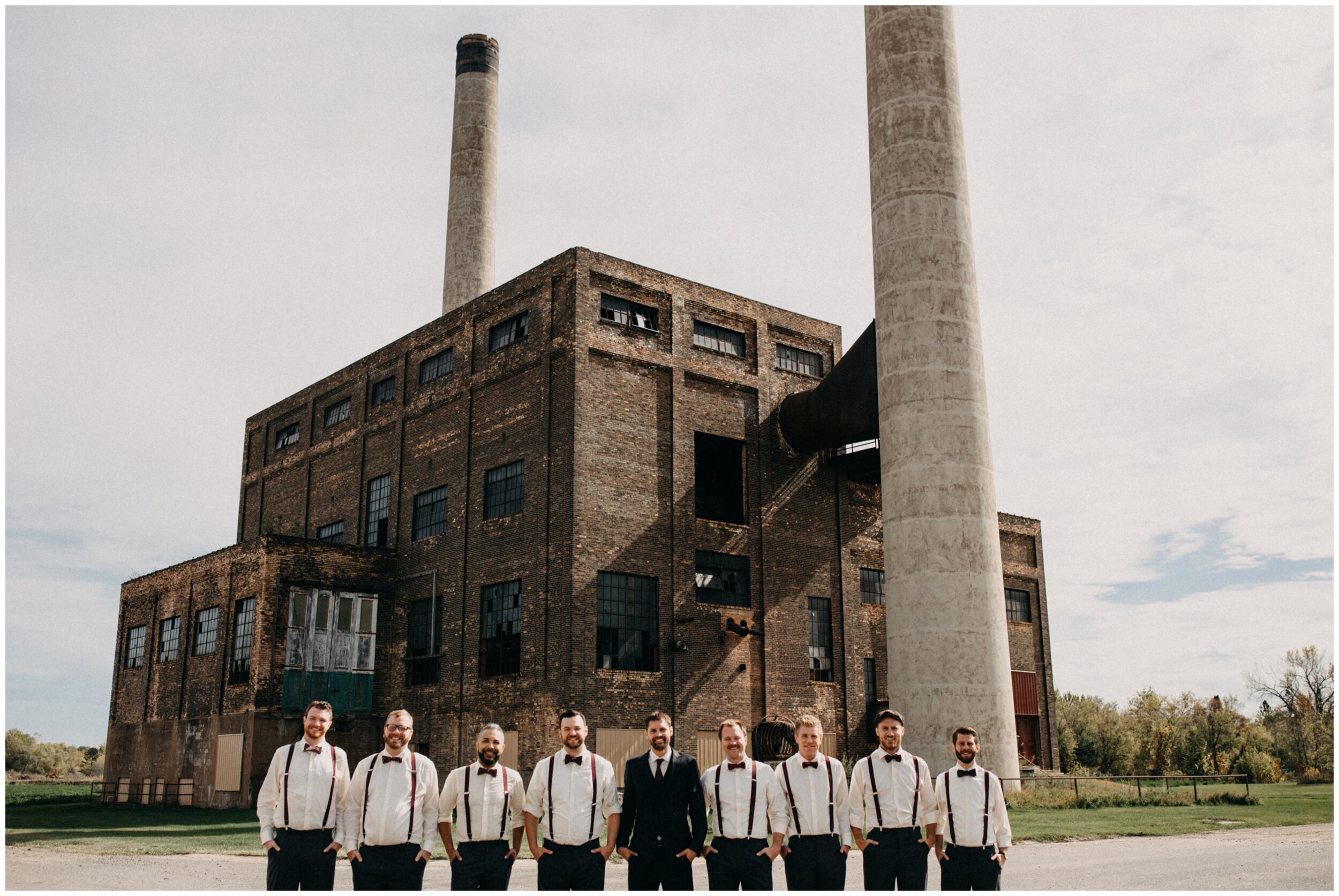 Groom and groomsman standing outside industrial wedding venue at the Northern Pacific Center in Brainerd, Minnesota
