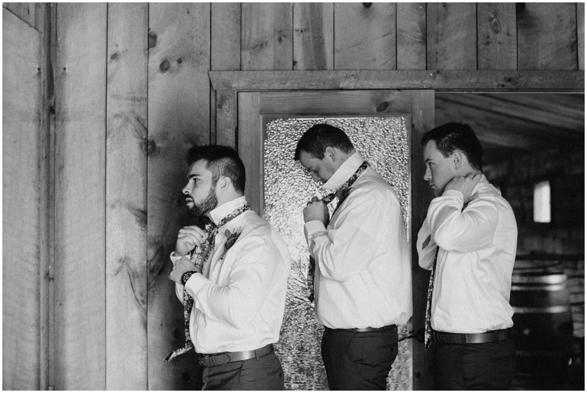 Groomsmen putting on ties for barn wedding at Creekside Farm